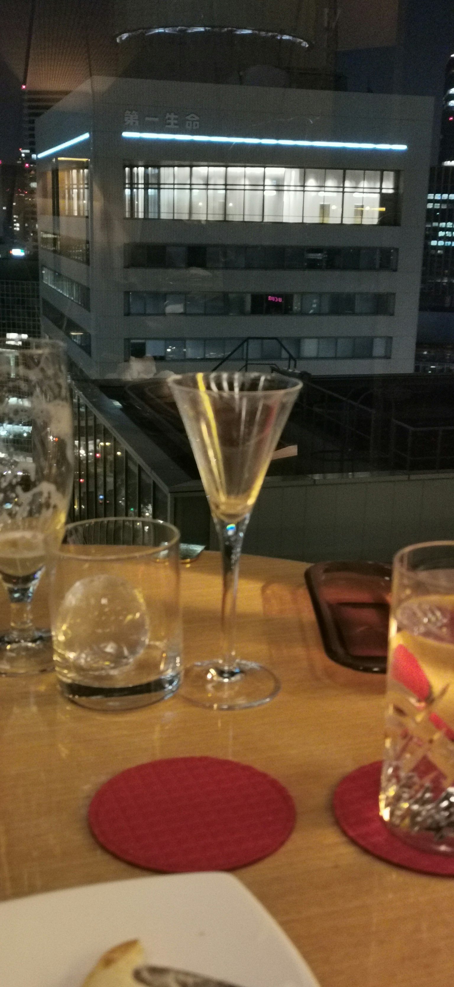 Elegante bicchiere da cocktail con vista sulla città di notte su un tavolo di ristorante