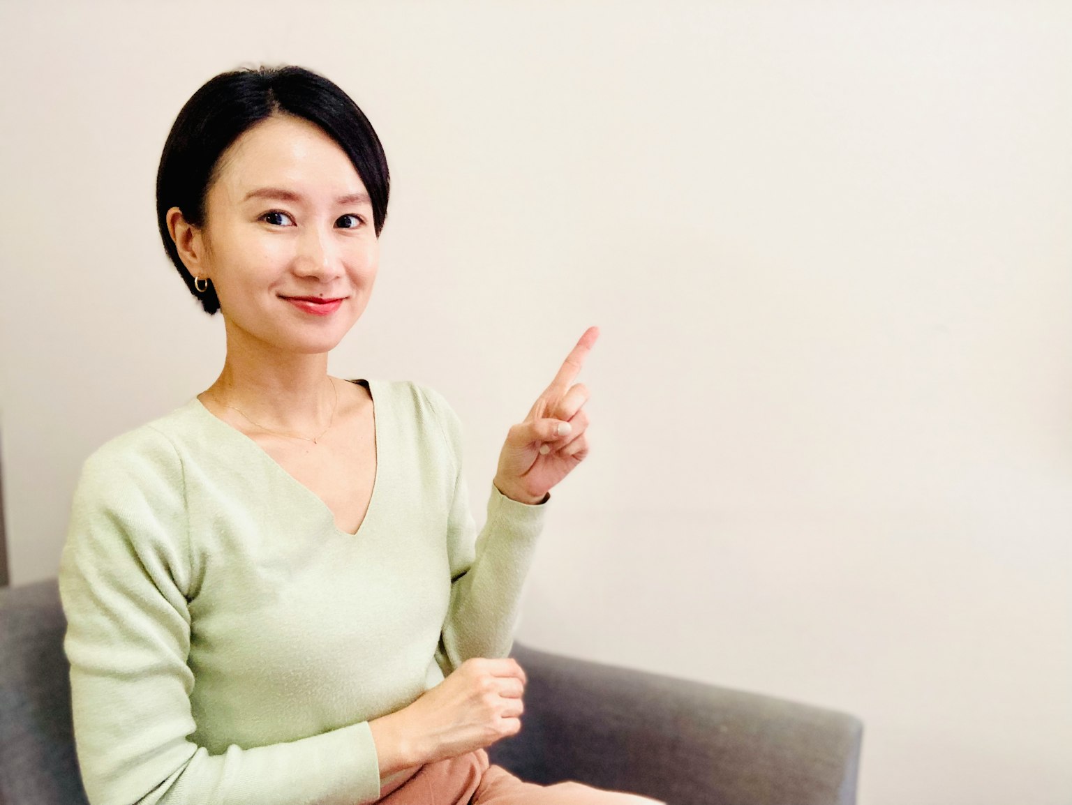 坐在沙發上的女性用手指指著