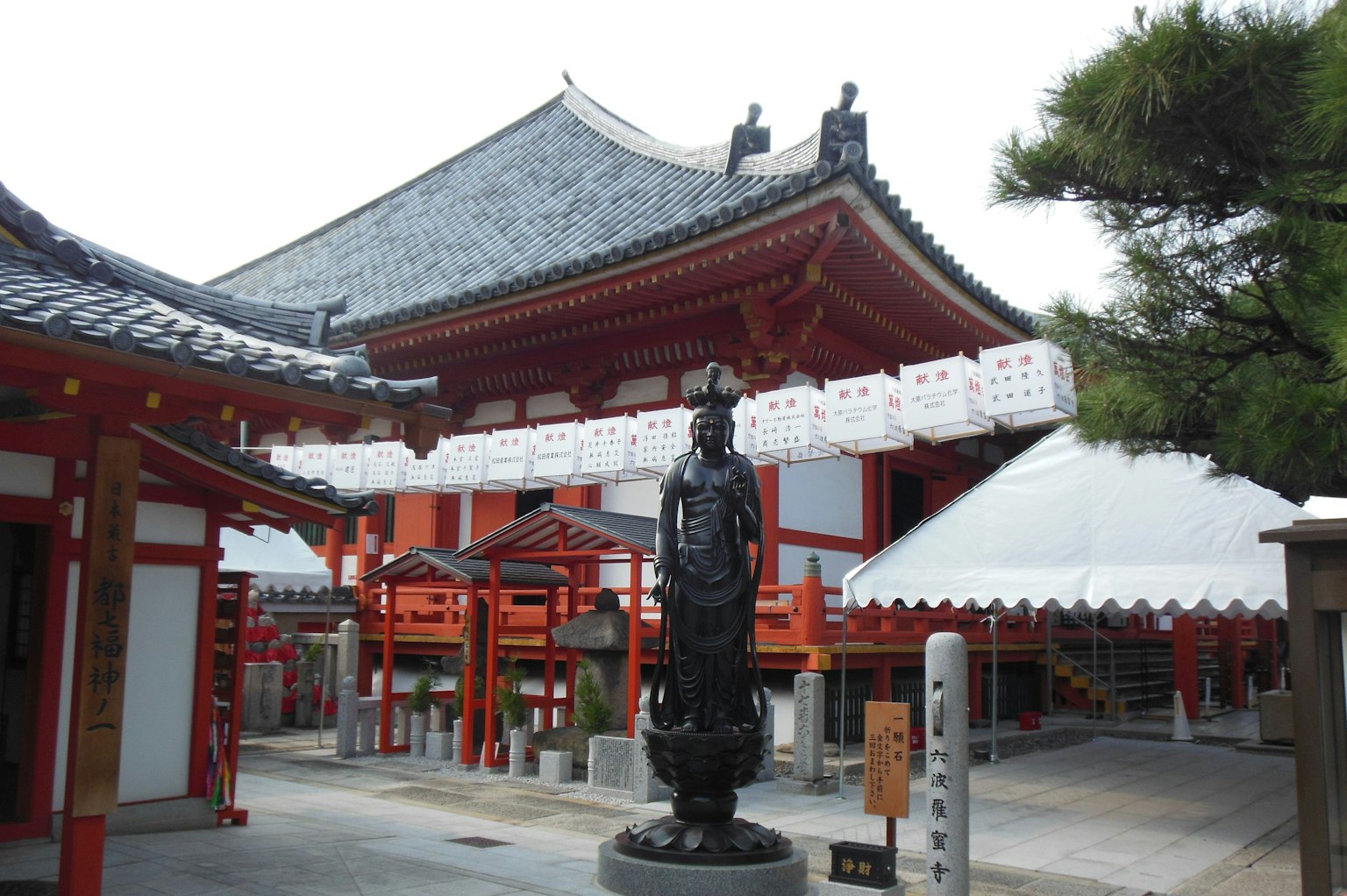 日本寺庙建筑前景有一座黑色雕像