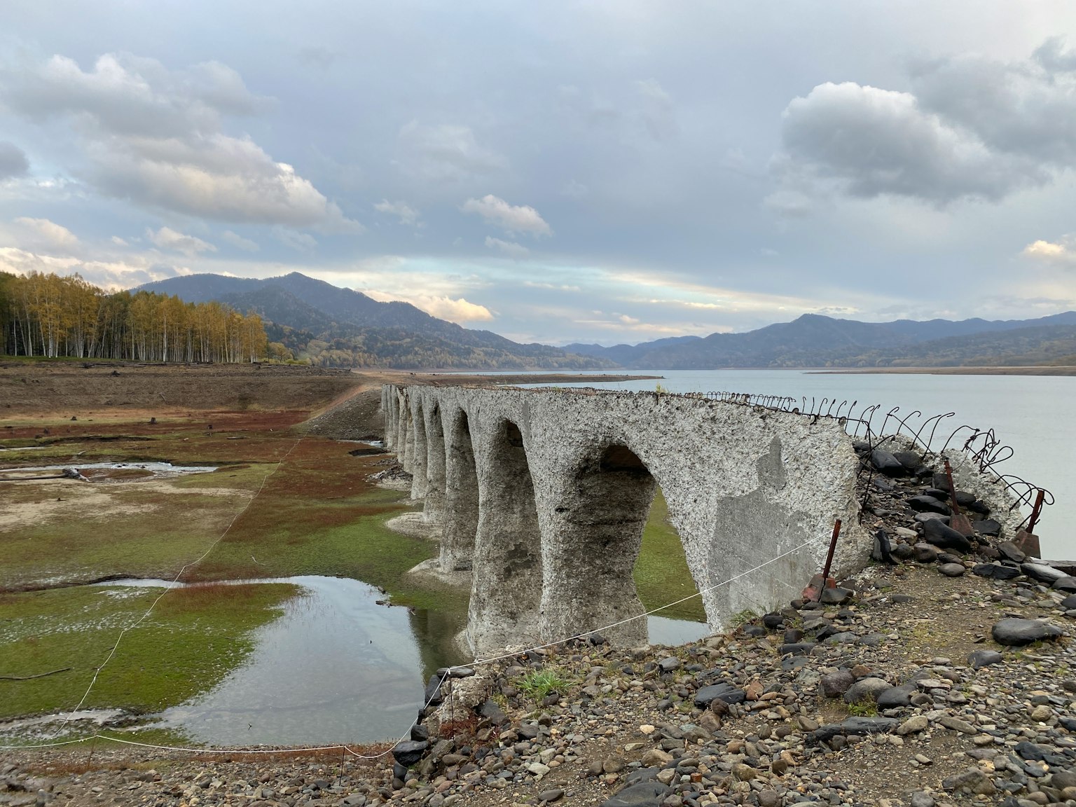 Antigua estructura de puente de piedra cerca de un lago seco