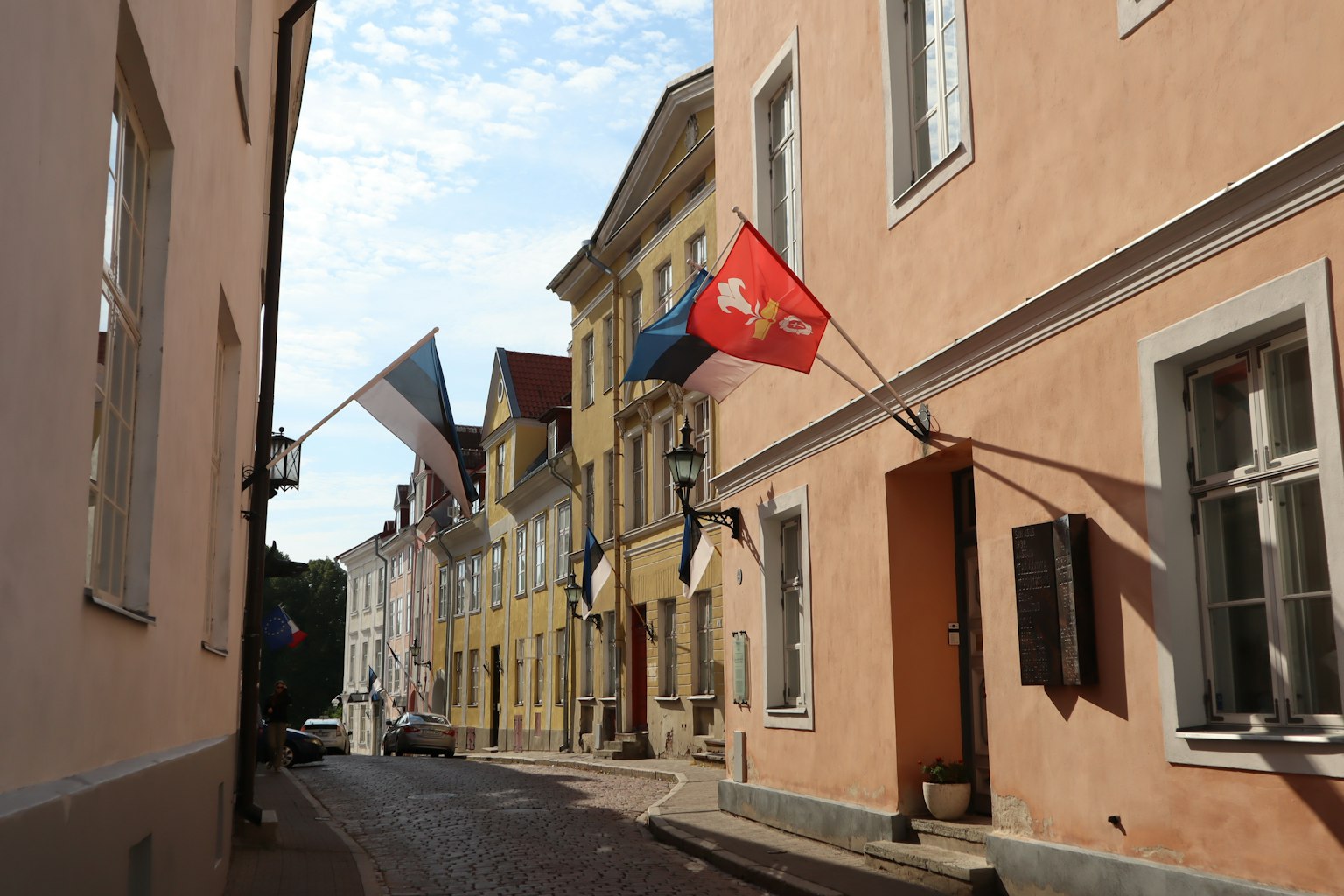 Narrow street lined with colorful buildings and flags displayed