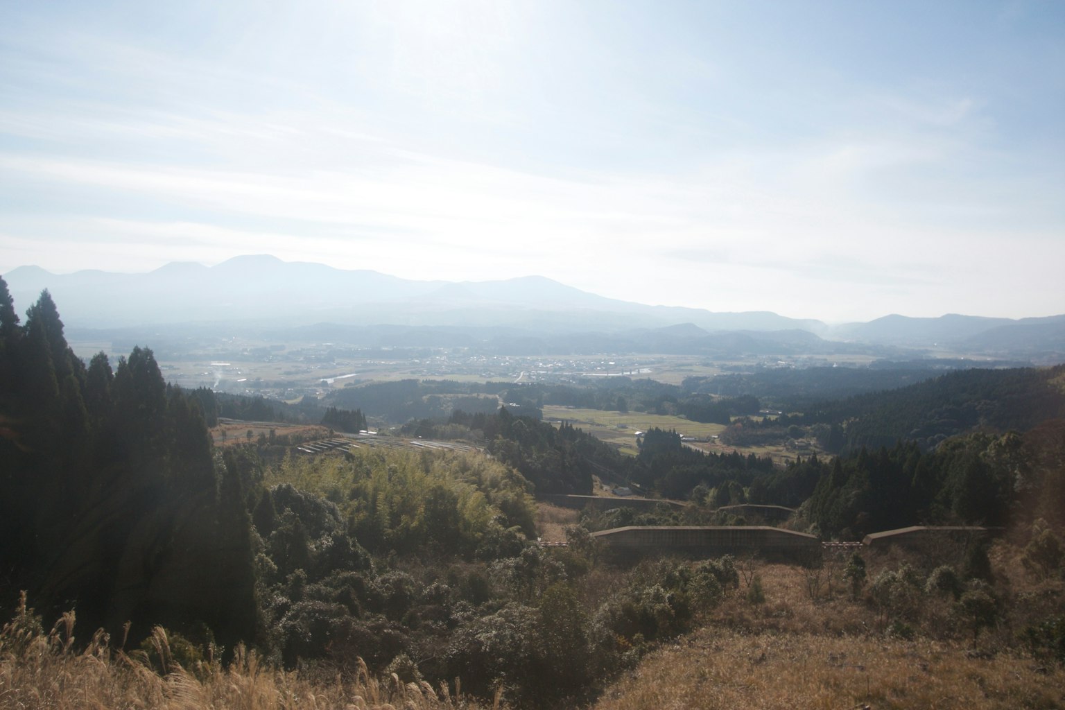 Una vista panoramica di valli verdi circondate da montagne sotto un cielo azzurro
