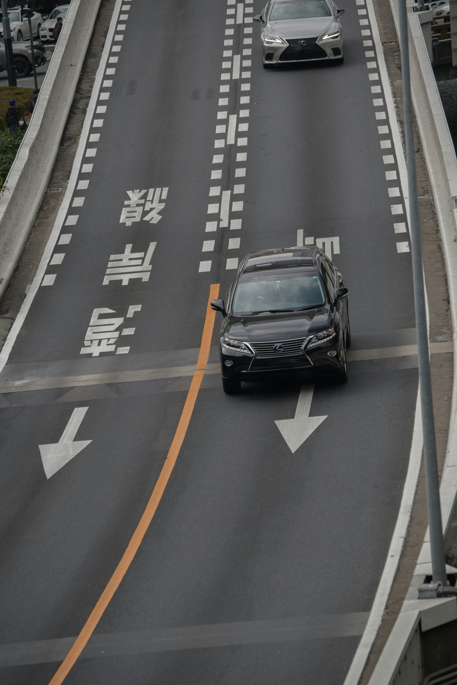 Black car driving on a highway with visible road signs