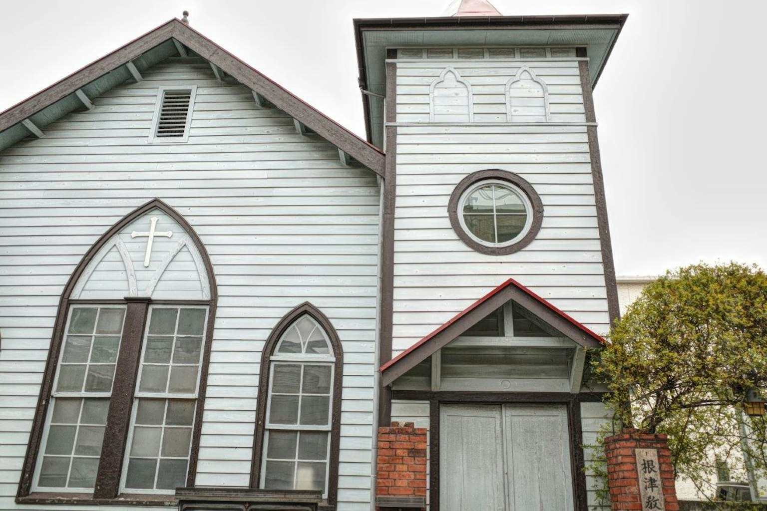 Exterior de una iglesia azul con un campanario y ventanas arqueadas