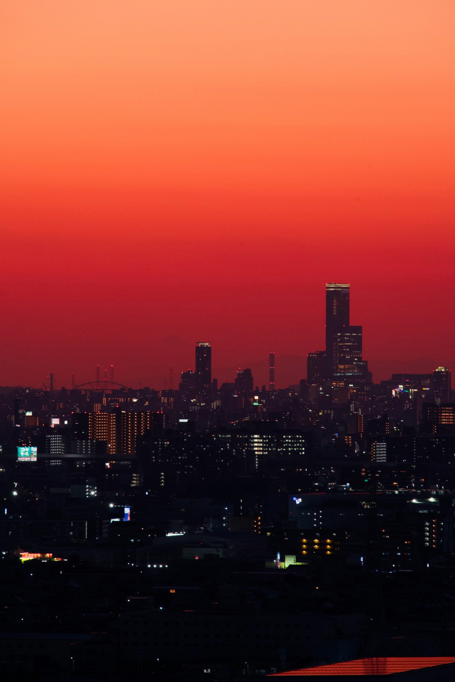 夕焼けの空と夜景が重なる都市のスカイライン