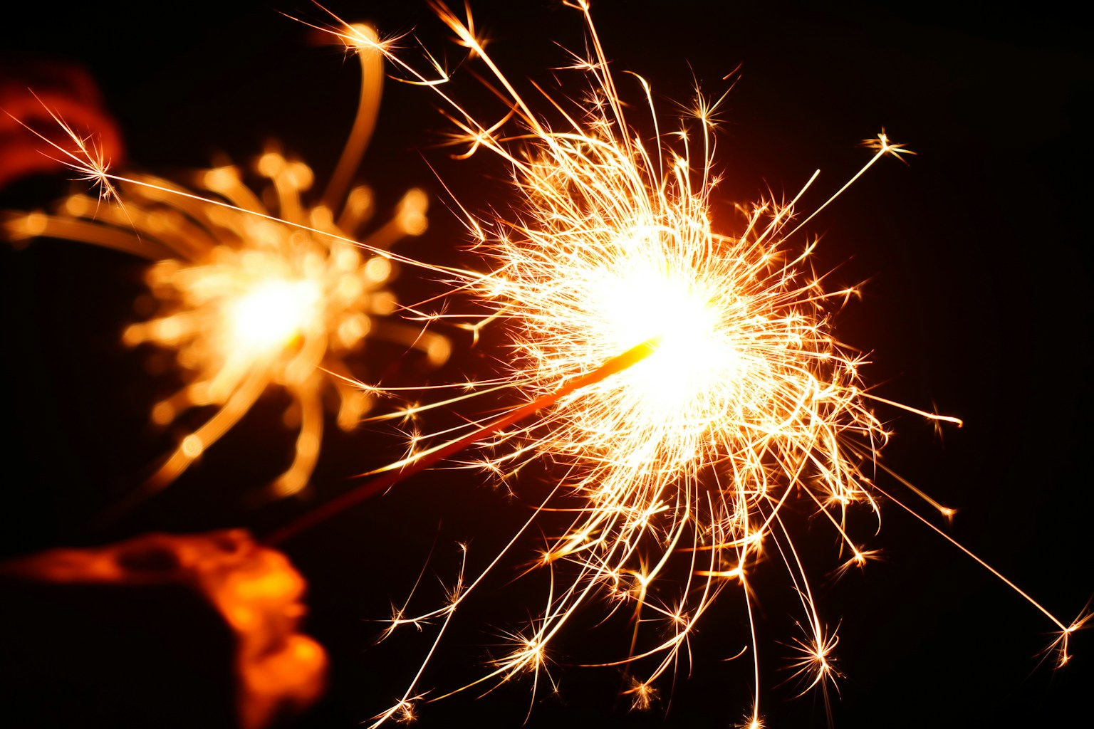 Close-up shot of a sparkler glowing against a dark background