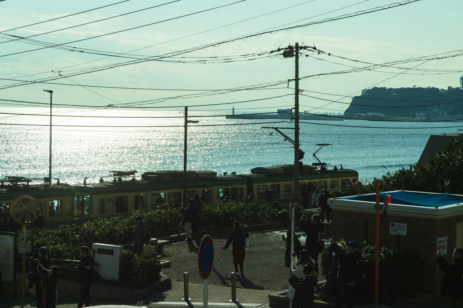 Coastal view with people gathering and a train passing by