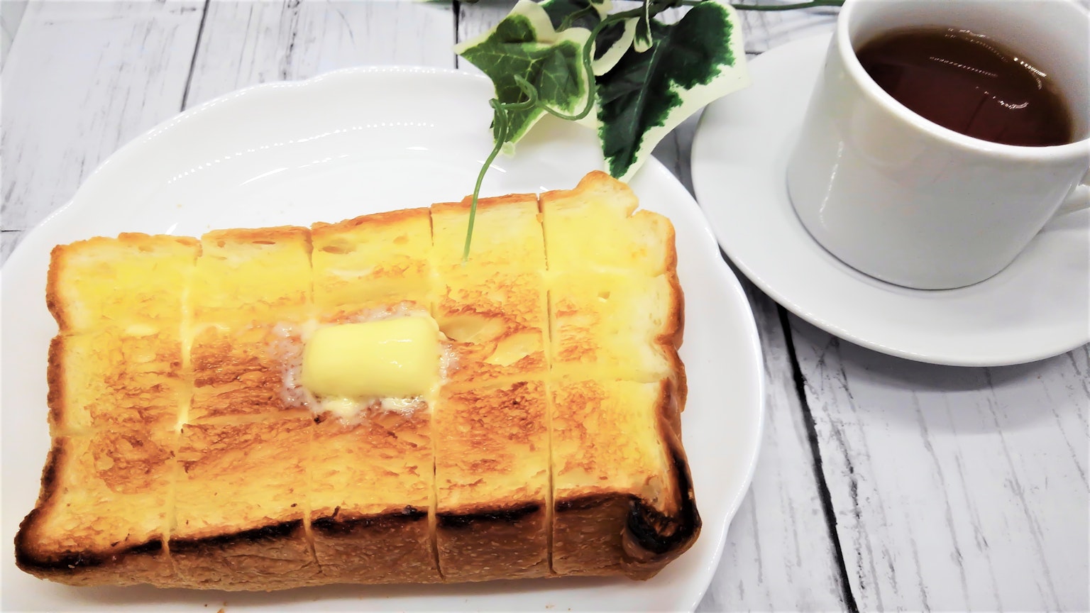버터가 발라진 토스트와 커피가 있는 아침 식사 접시
