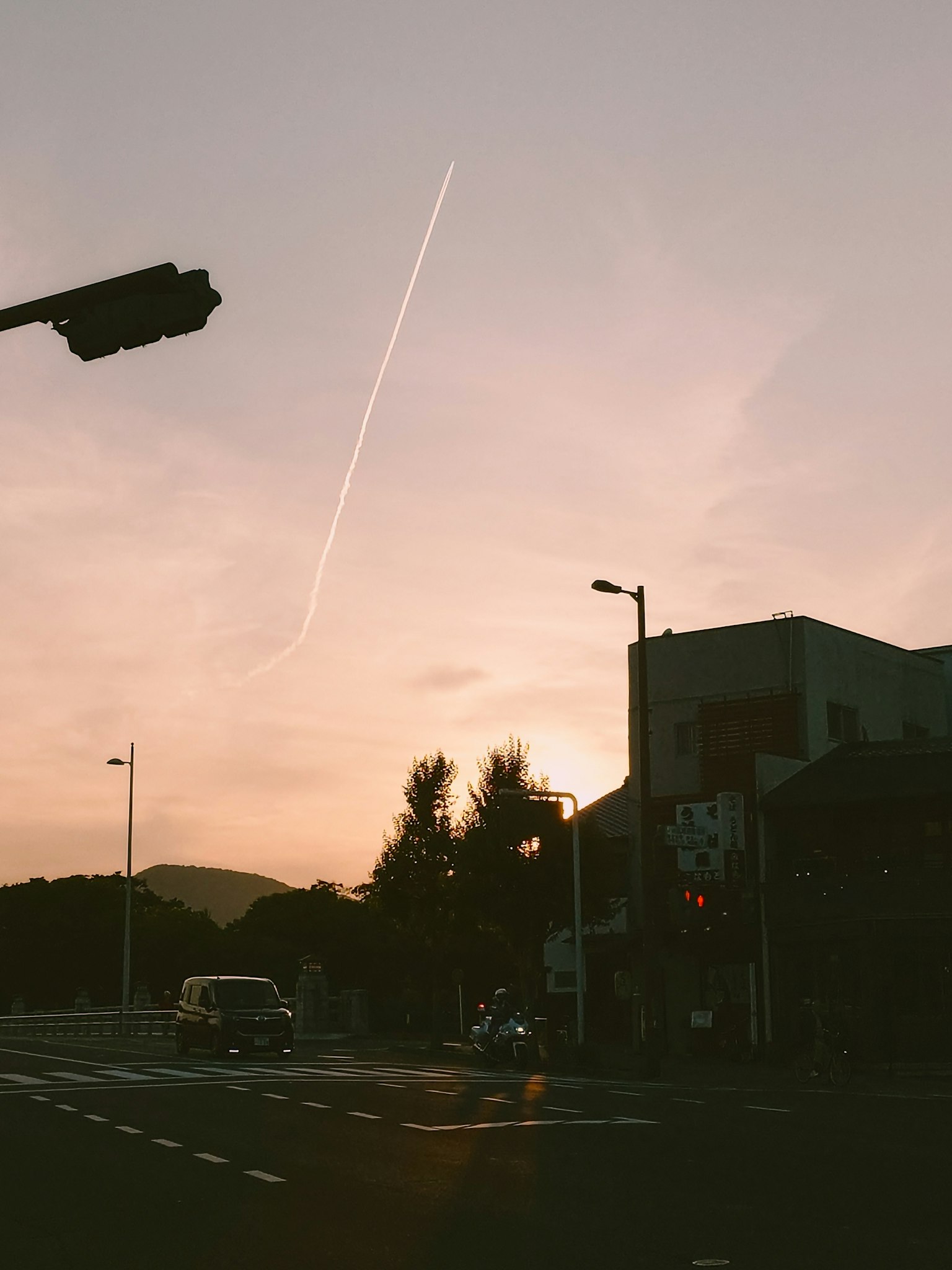 Intersección con un cielo al atardecer y una estela de avión