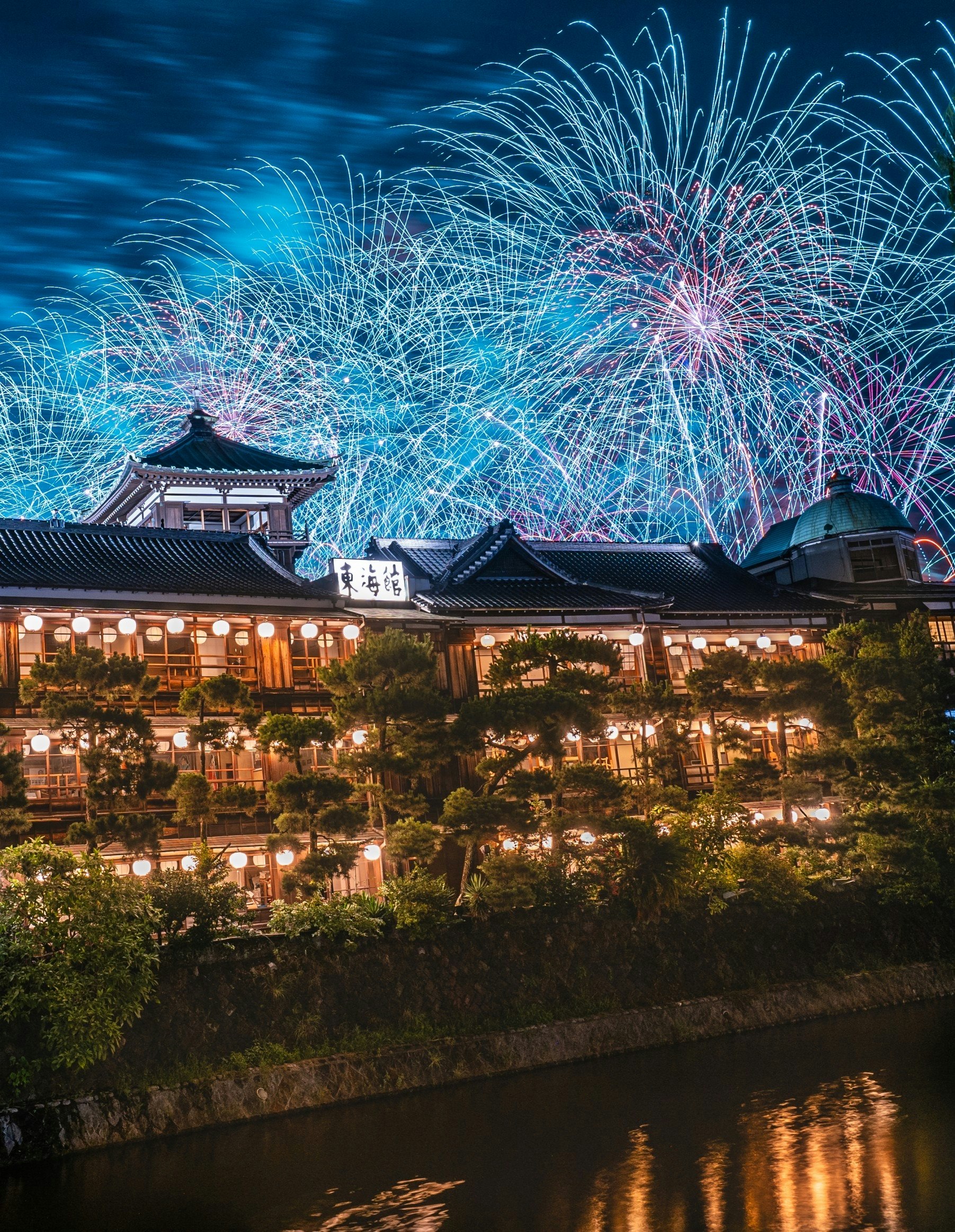 伊東市の按針祭花火大会で打ち上がる花火と夜景の街並み