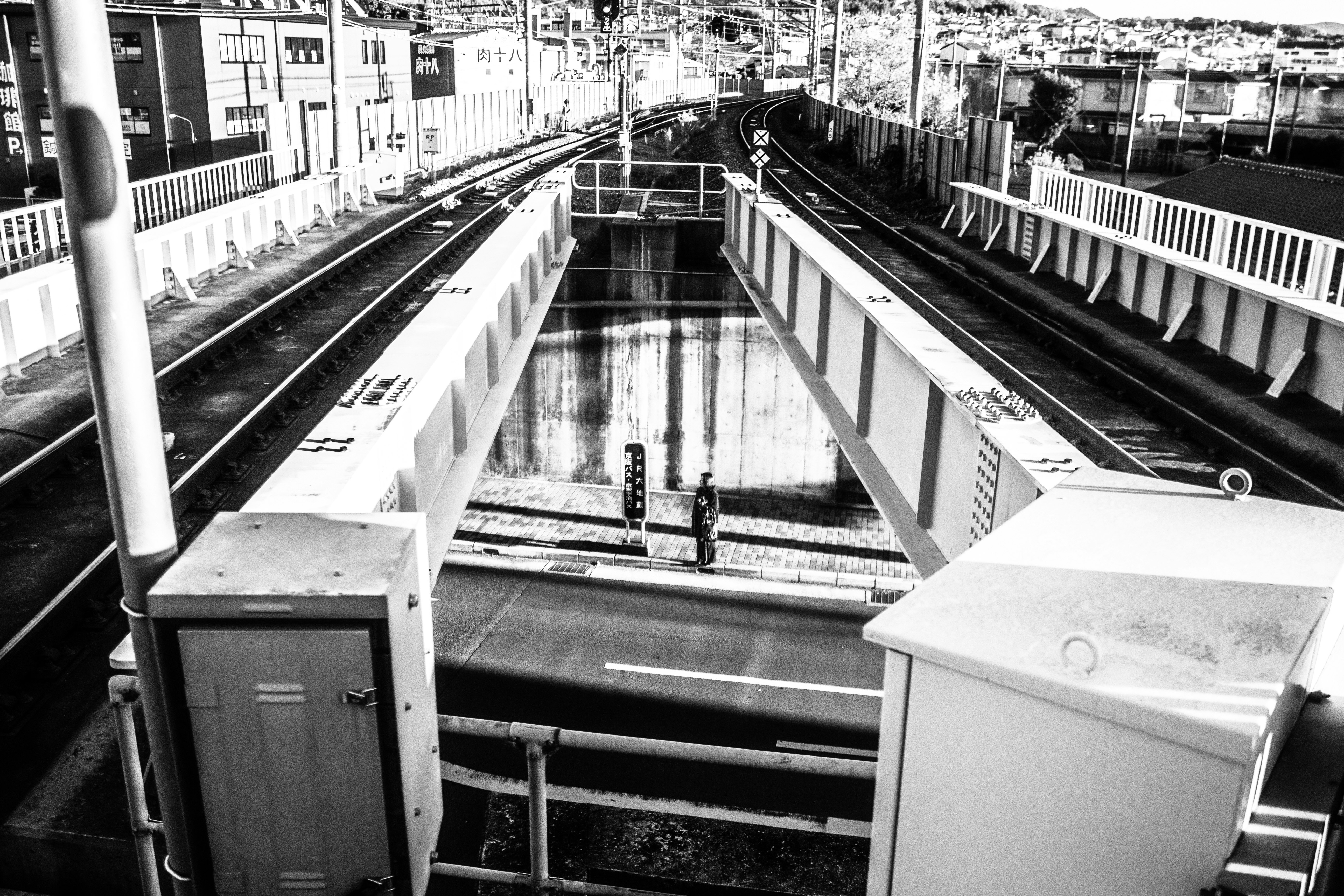 京都の線路沿いに並ぶ柵と機械設備のある構内