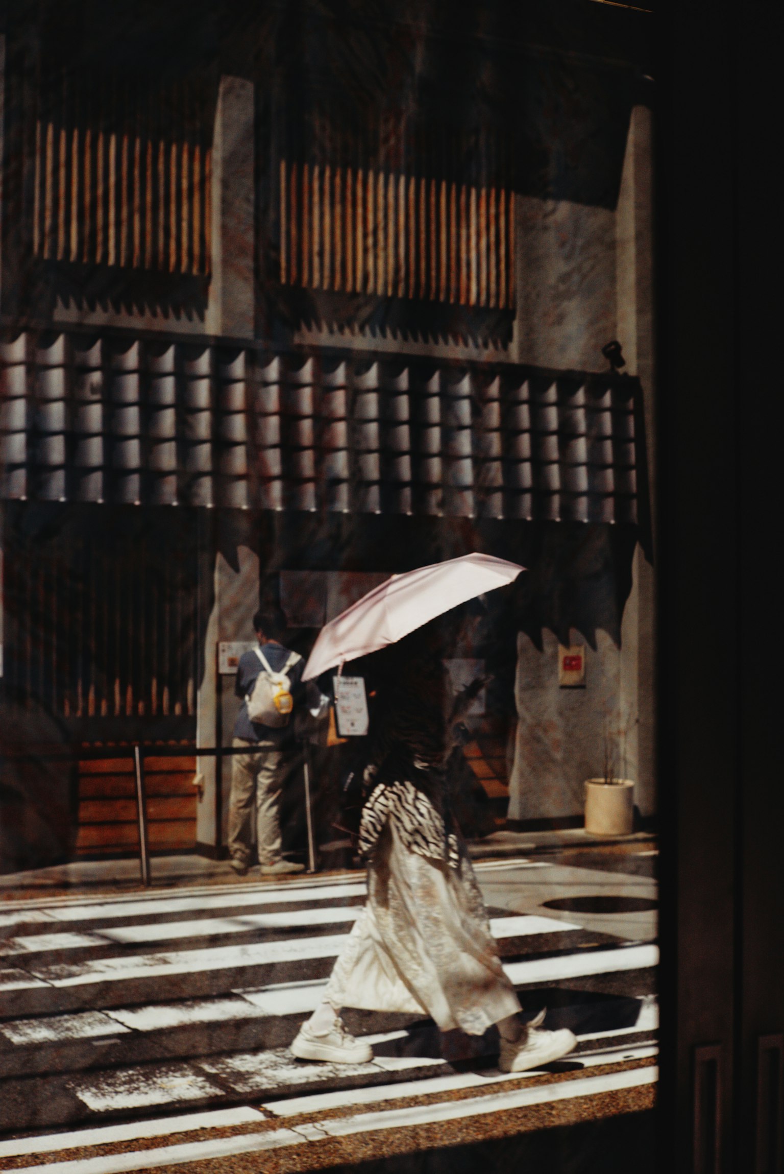 Người phụ nữ trong trang phục kimono cầm ô băng qua đường đi bộ