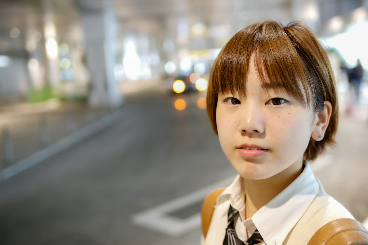 Ritratto di una giovane donna sorridente in una stazione con sfondo urbano sfocato