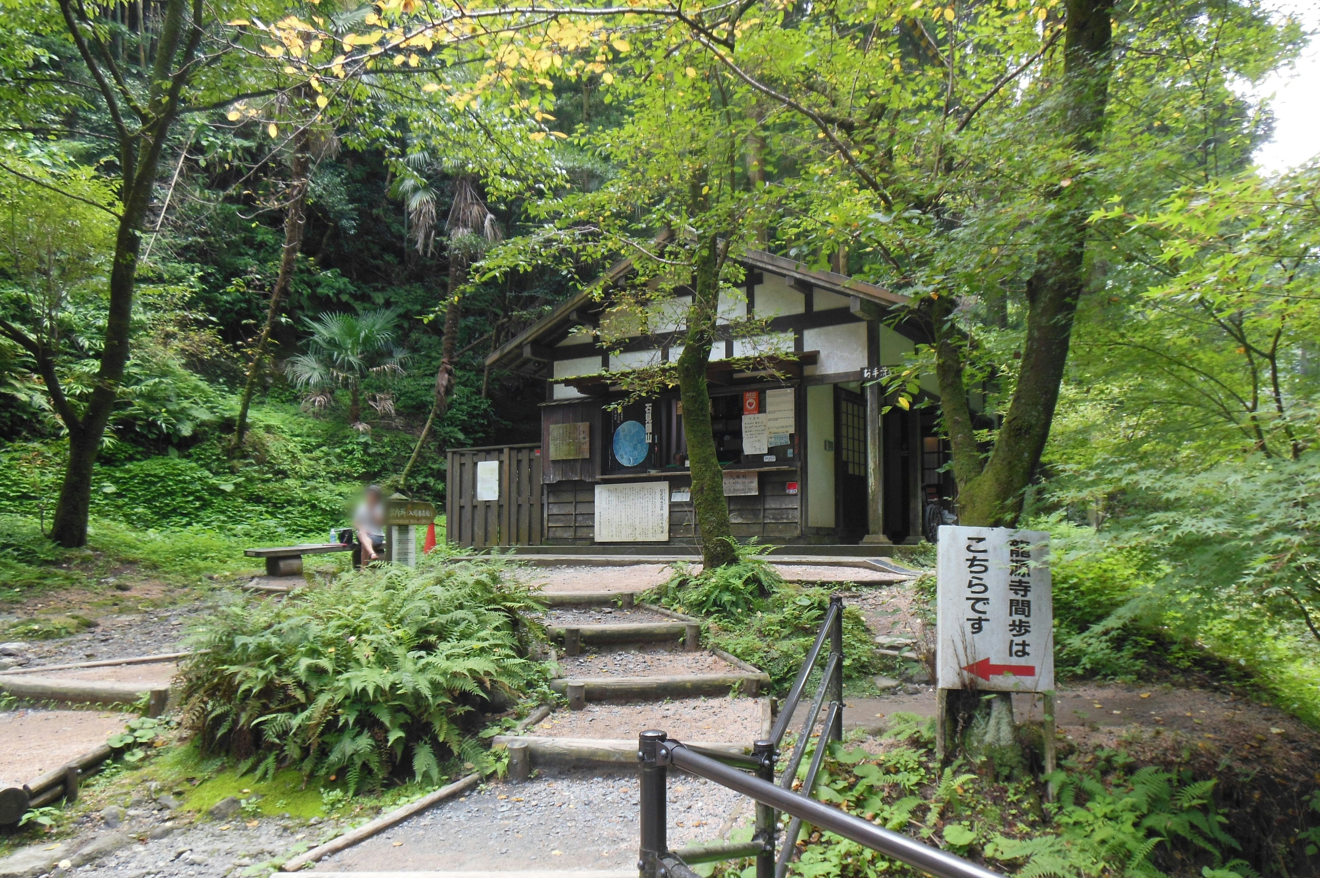 緑の森の中にある小さな休憩所と案内板