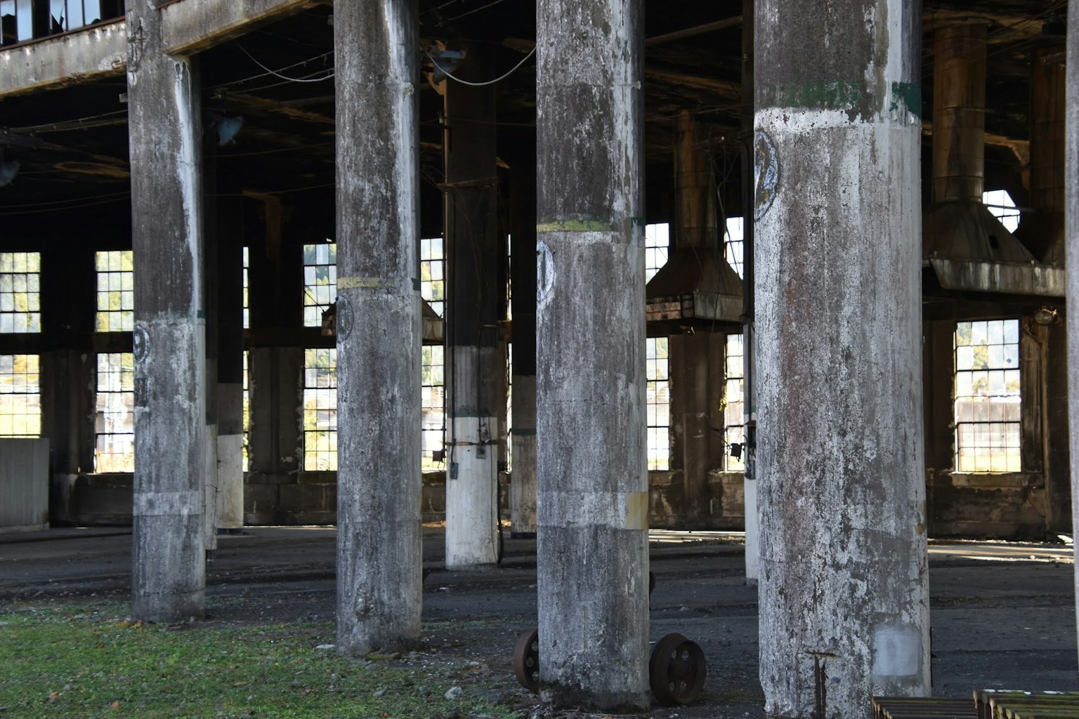 Vista interna di una vecchia fabbrica con colonne usurate e grandi finestre