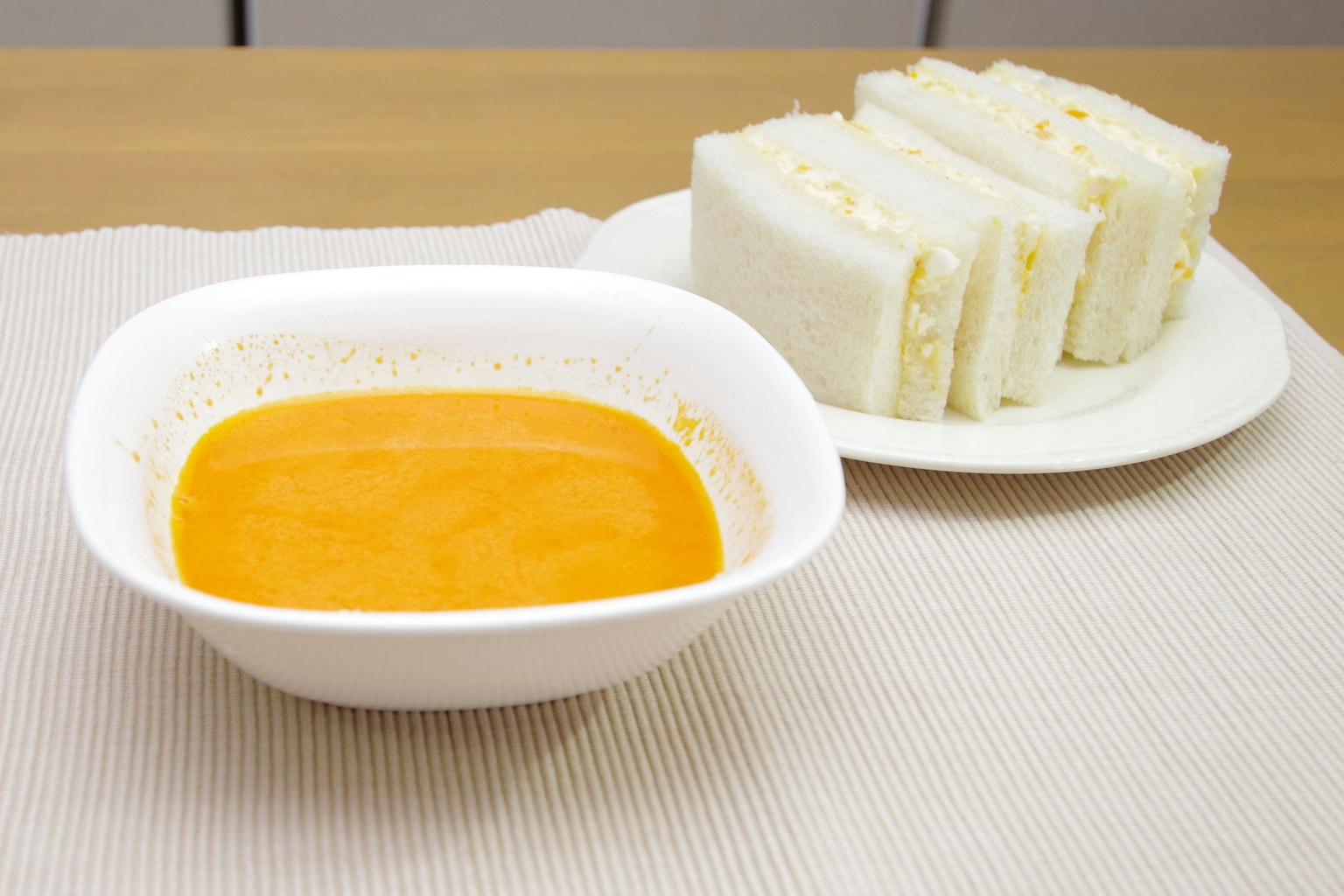 Sándwiches blancos servidos con un tazón de salsa naranja