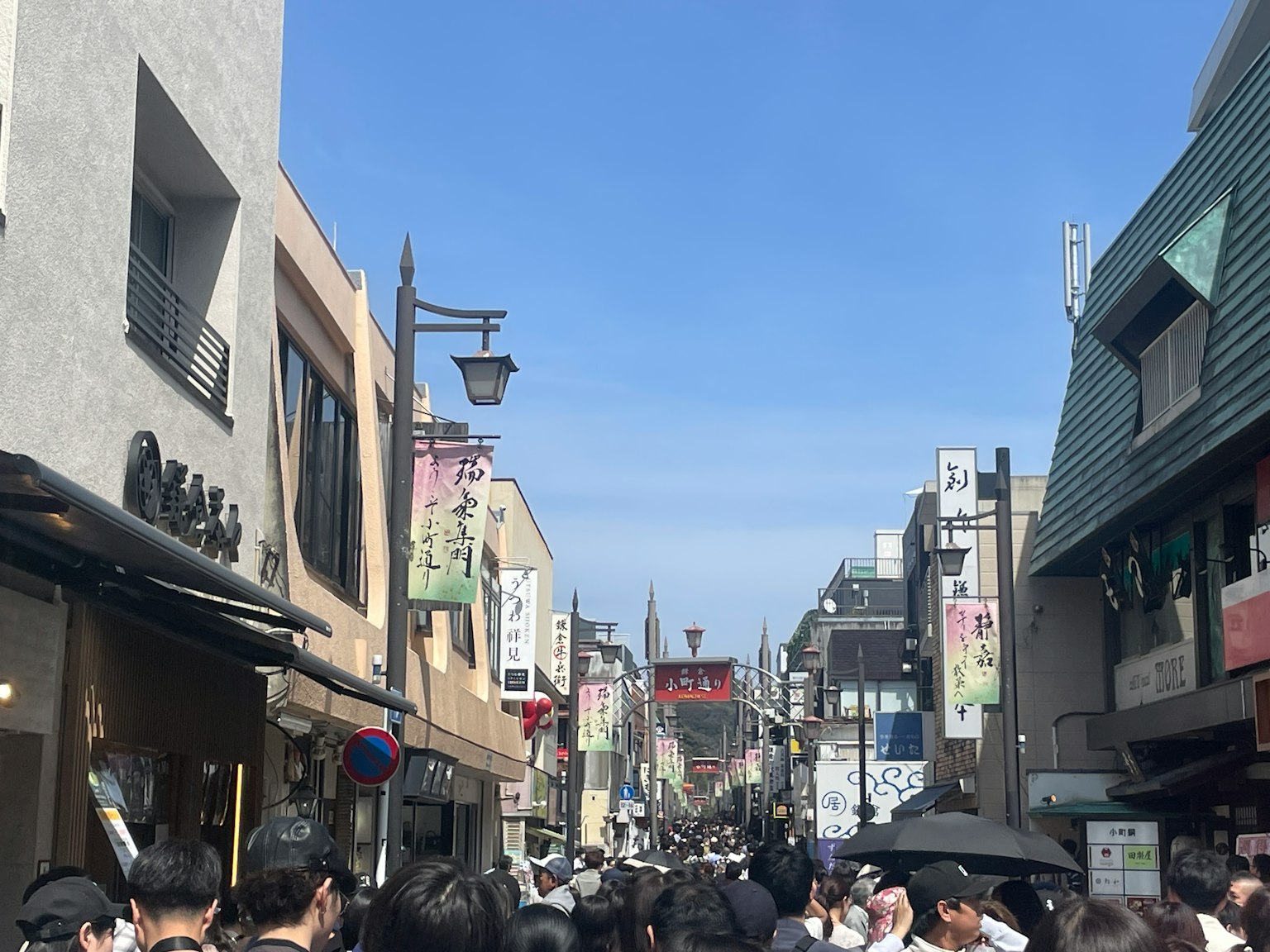 Multitud de personas en una calle concurrida bajo un cielo azul