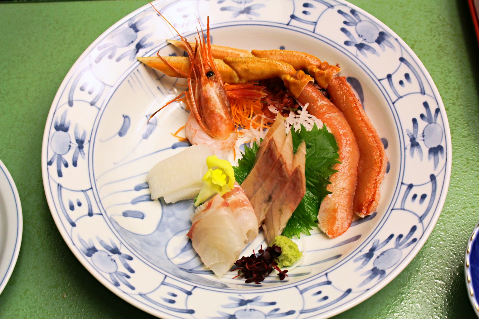 Ein schön angerichteter Teller mit buntem Sashimi und frischen Garnelen