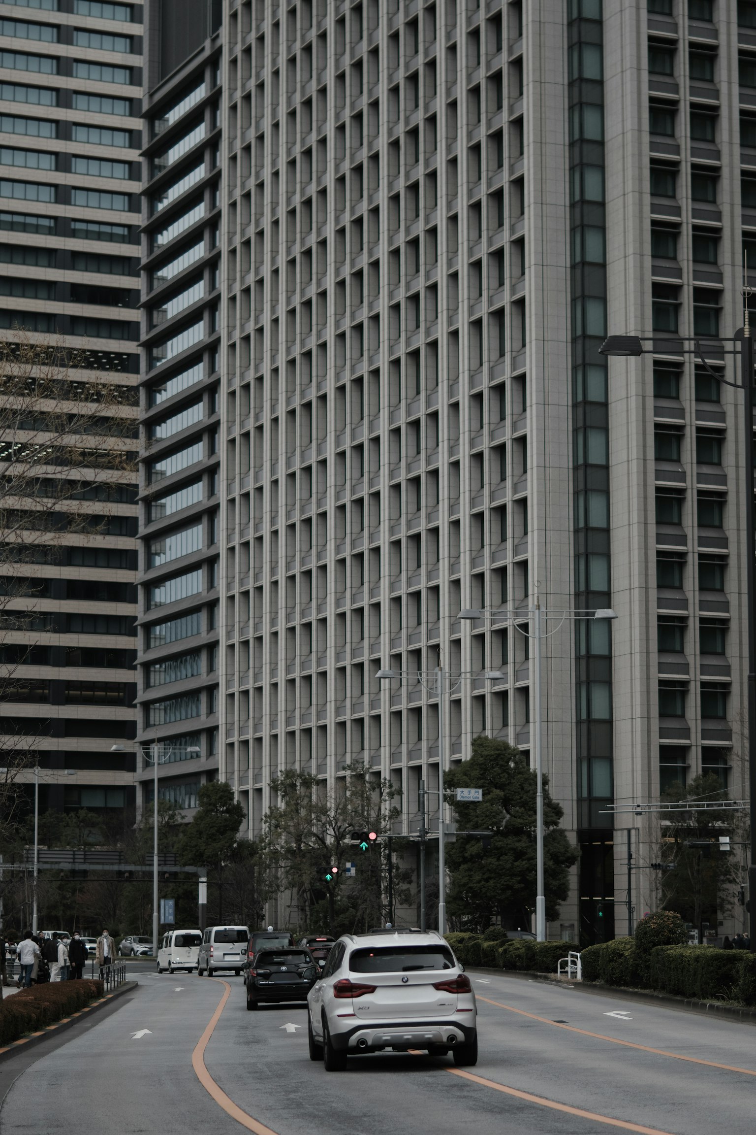 Una escena de calle con coches pasando junto a edificios altos