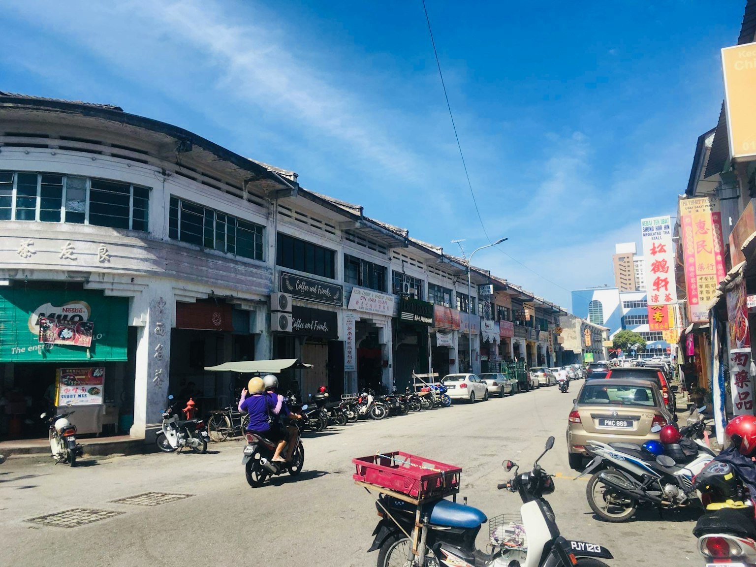 晴朗的白天街道場景，有商店和摩托車