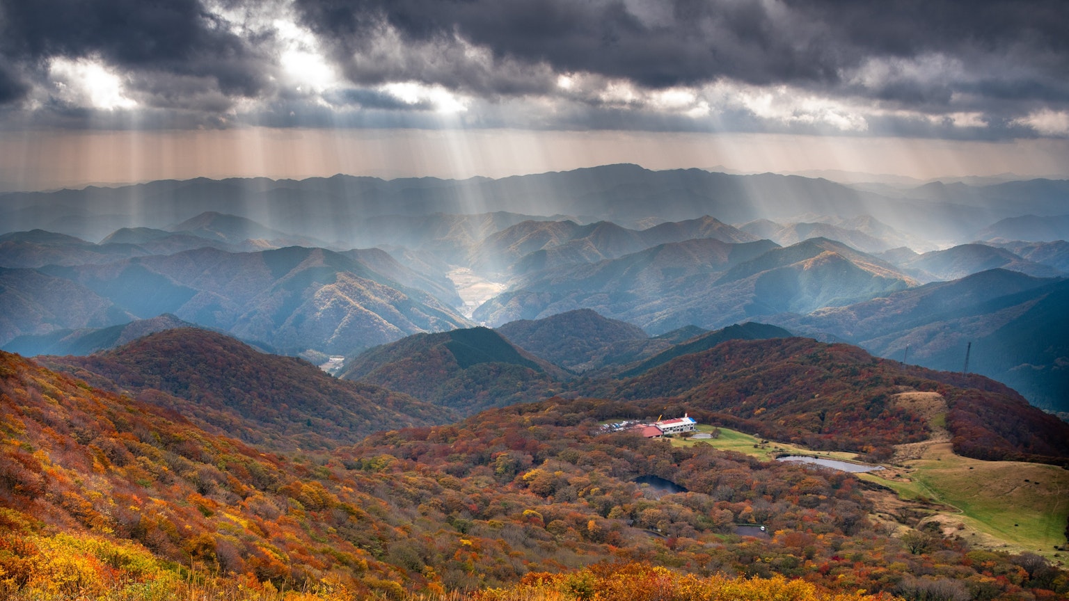 ทิวทัศน์ที่สวยงามของภูเขาที่มีสีสันของฤดูใบไม้ร่วงพร้อมกับแสงที่ส่องผ่านหมอก
