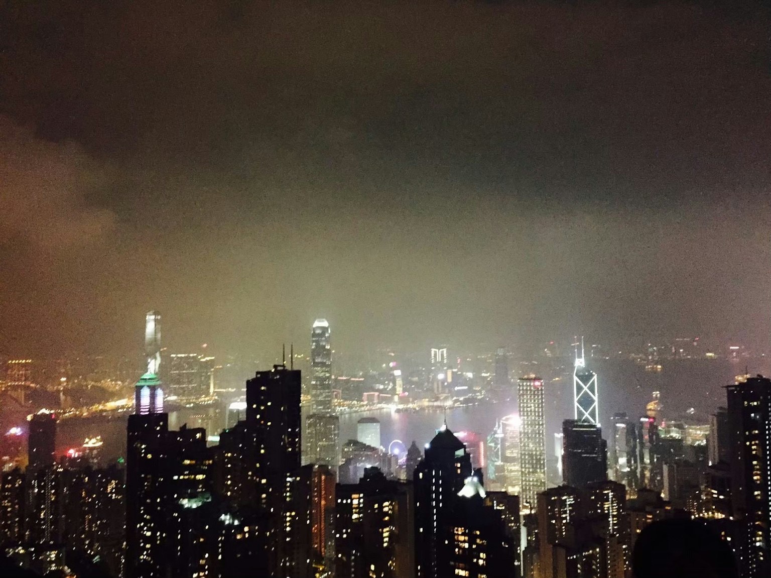 Vista nocturna del horizonte de Hong Kong con rascacielos y niebla