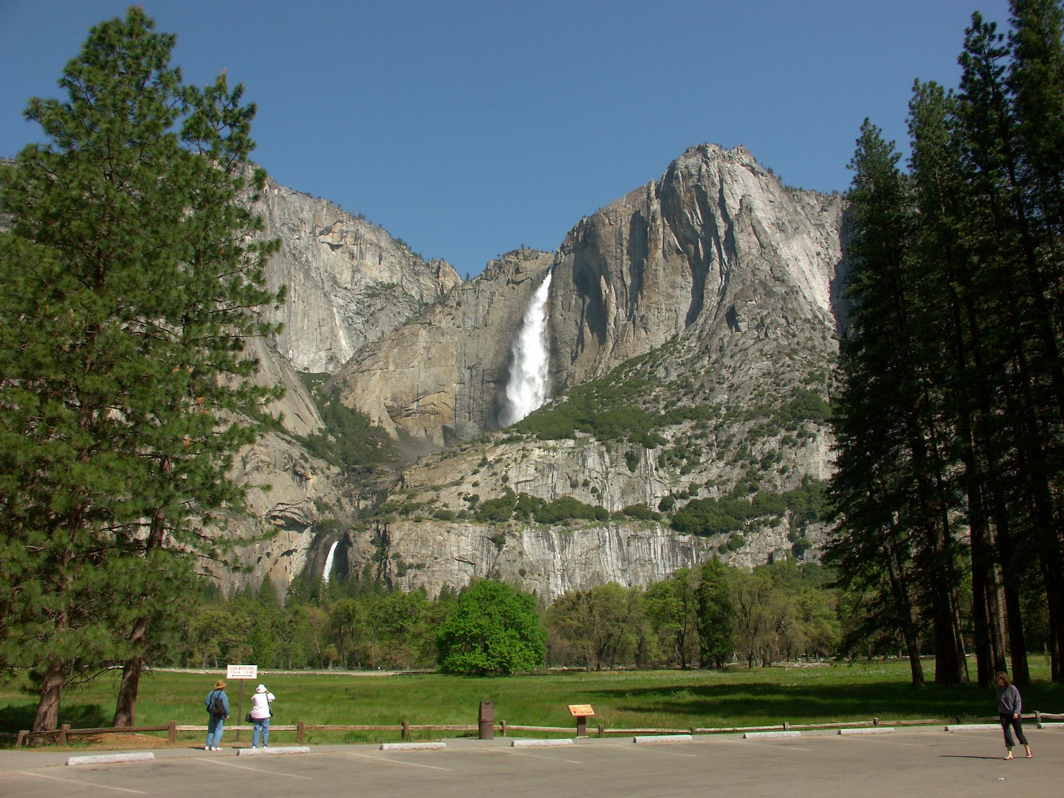Paisaje majestuoso del Parque Nacional Yosemite con cascadas y un prado verde