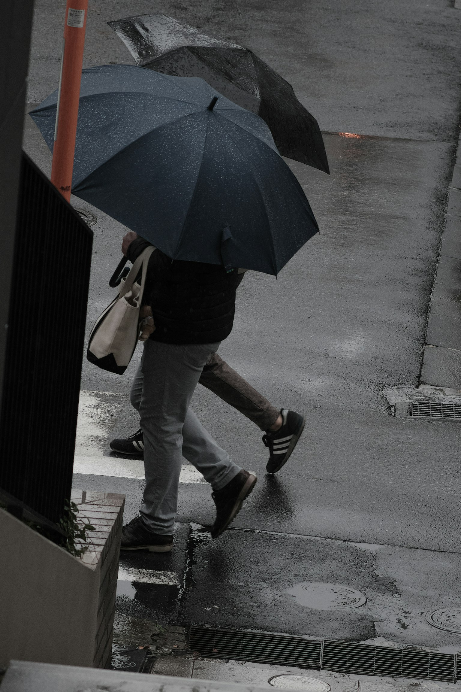 人在雨中撐著傘走路
