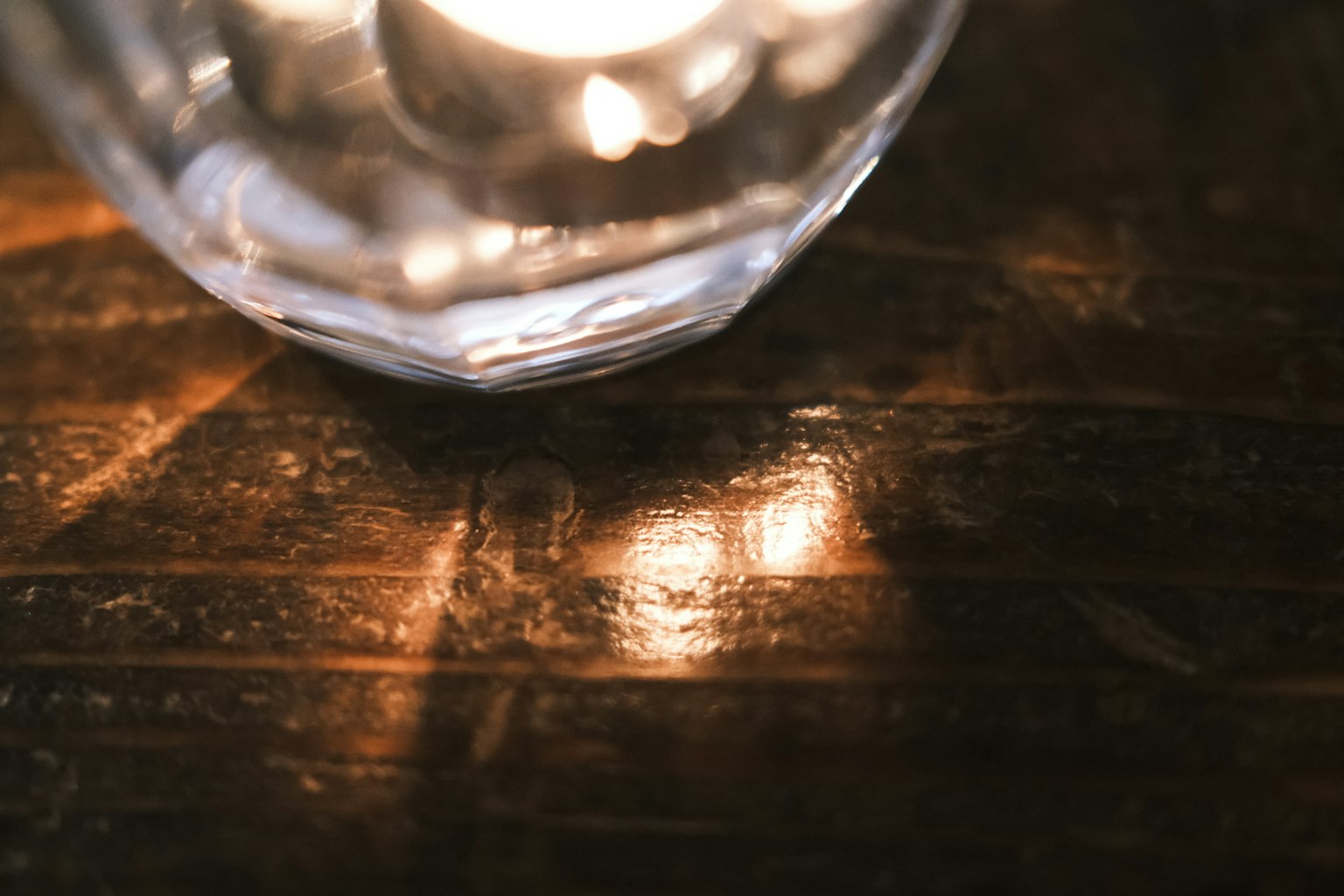Bougie lumineuse dans un support en cristal sur une table en bois