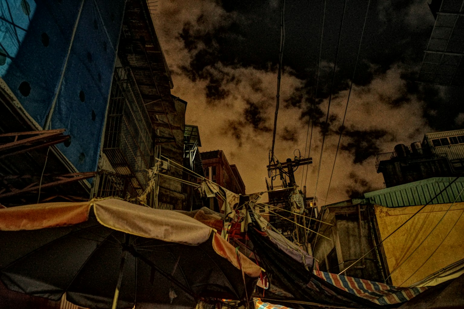 Escena de mercado nocturno con puestos y cielo oscuro