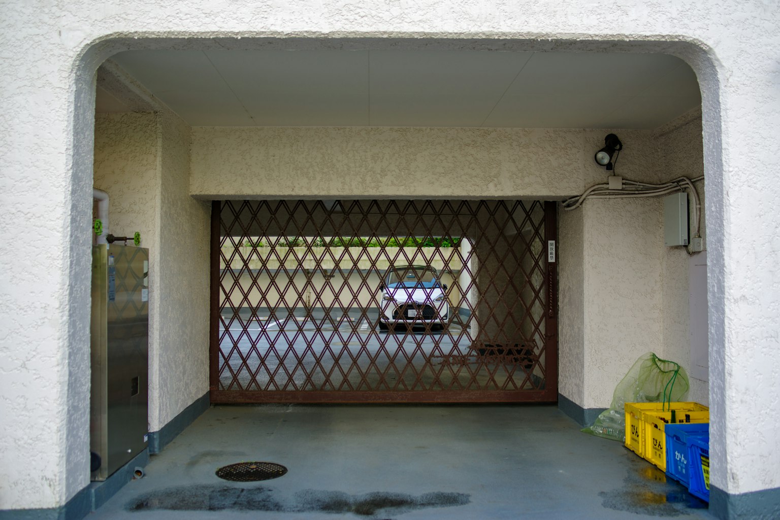 Garage entrance with a grid door and a car inside