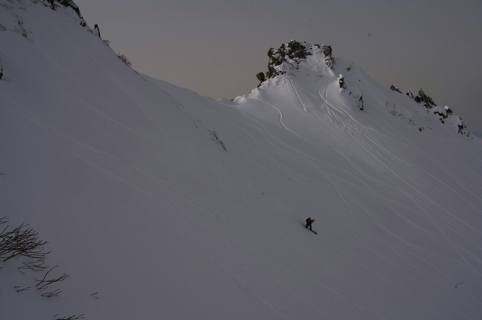 Snow-covered mountain slope with dark sky