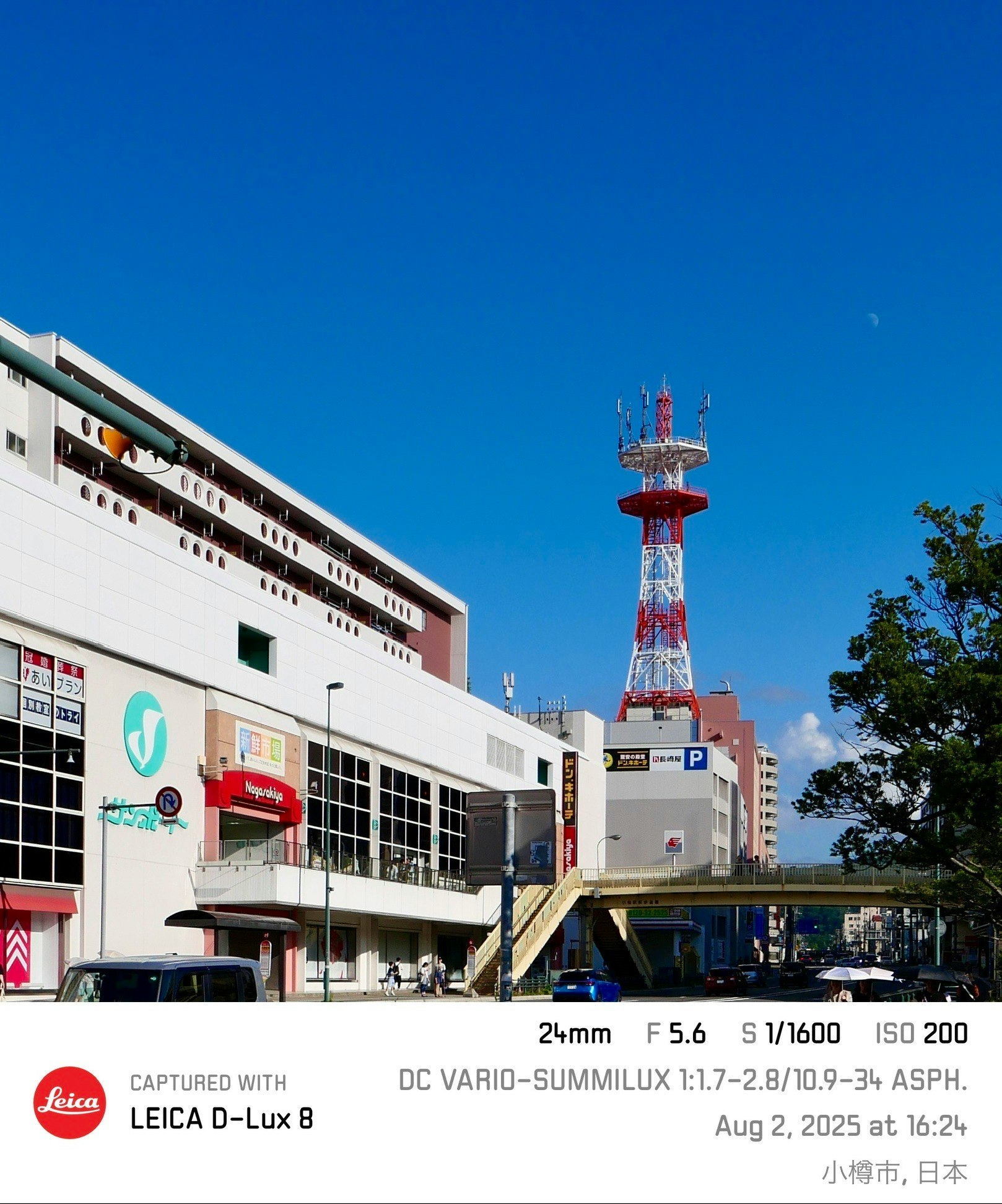 Red-and-white observation tower and station buildings under a blue sky