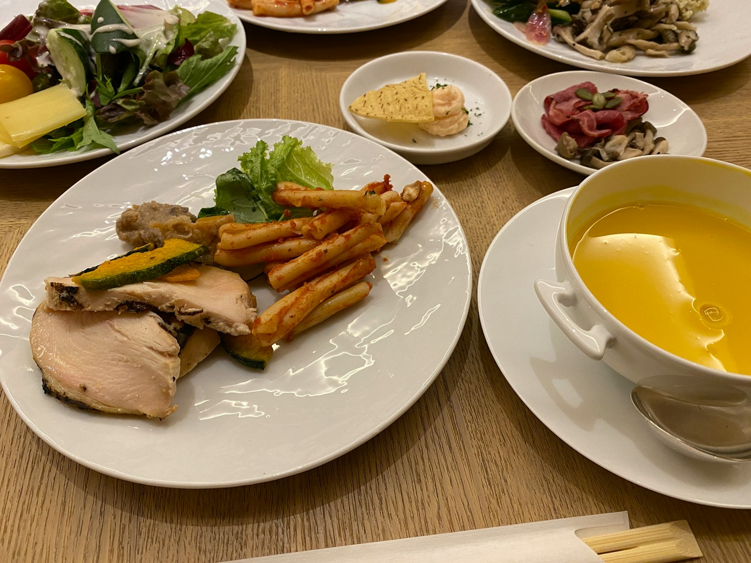 Una comida con pollo, papas fritas, ensalada y sopa