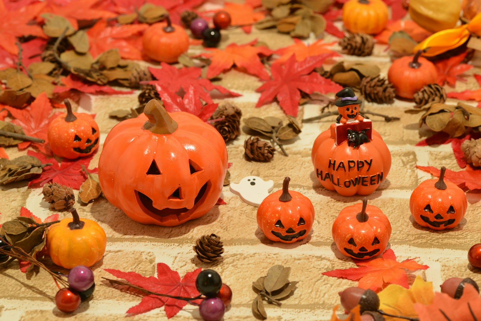 Halloween-Szene mit orangefarbenen Kürbissen und roten Blättern