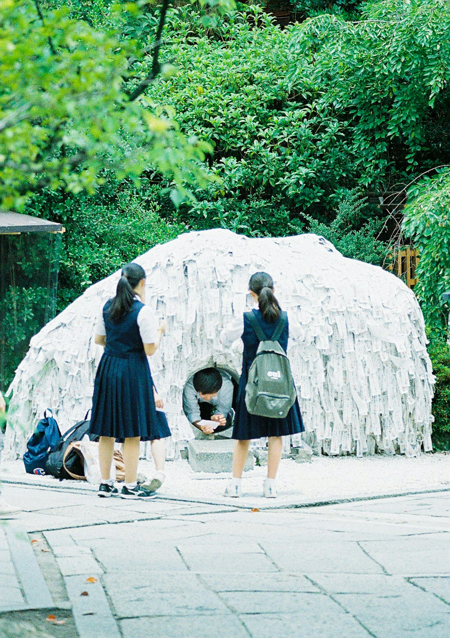 学生站在一座白色布料覆盖的雕塑前