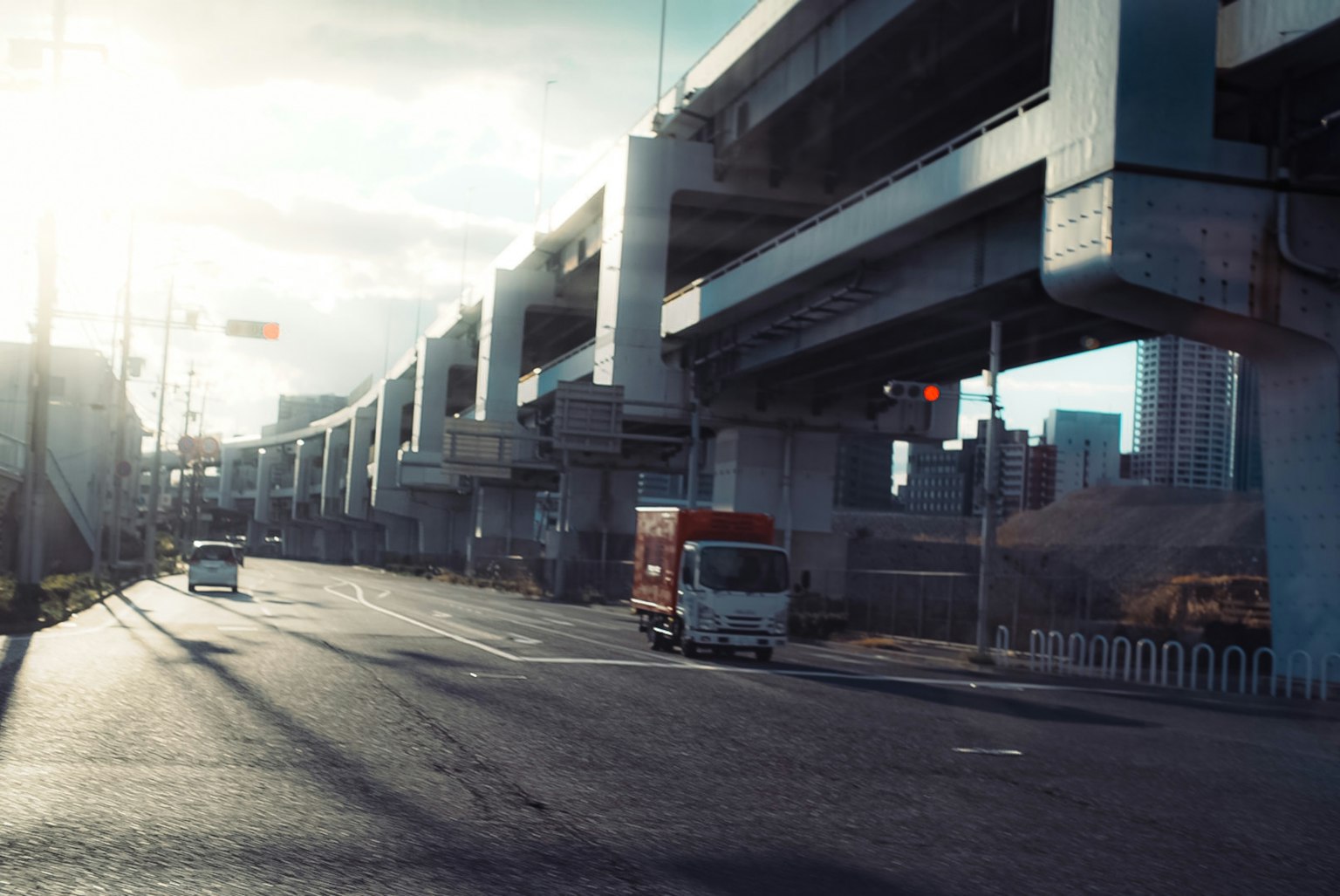 Leere Straße unter einer erhöhten Autobahn mit einem roten Lastwagen