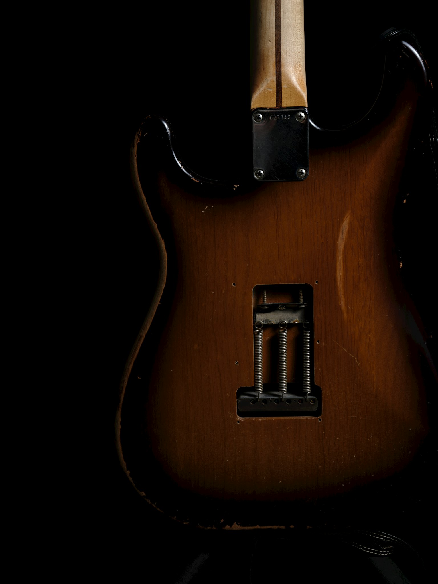 Un corps de guitare électrique sunburst sur fond noir