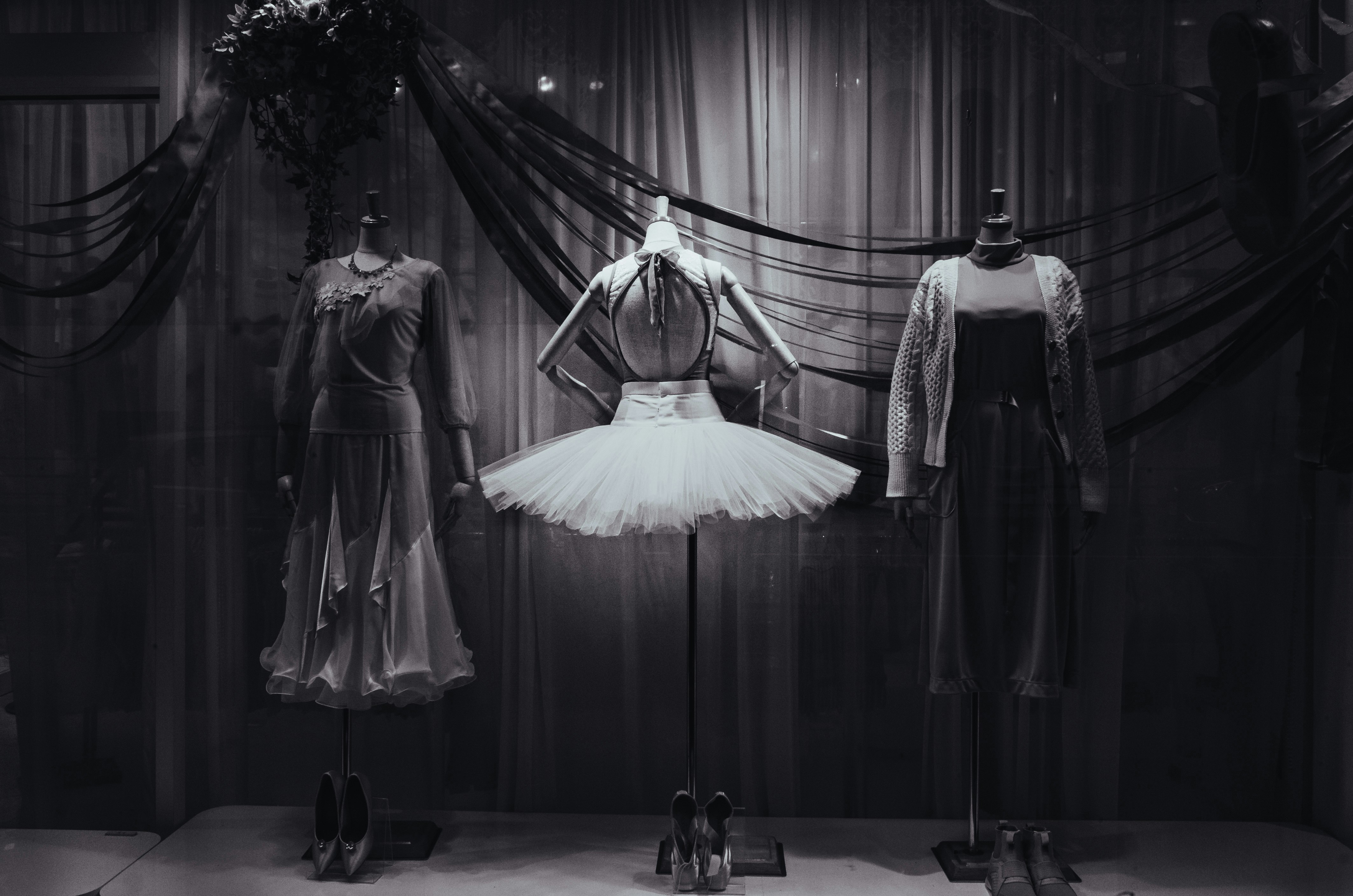 Ballet costumes and pointe shoes displayed in front of curtains