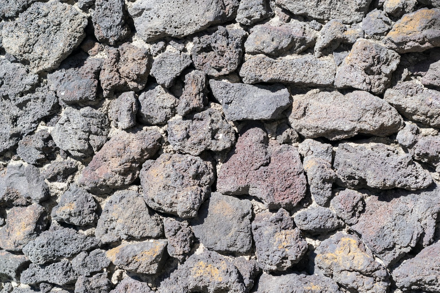 Pared texturizada de rocas volcánicas negras