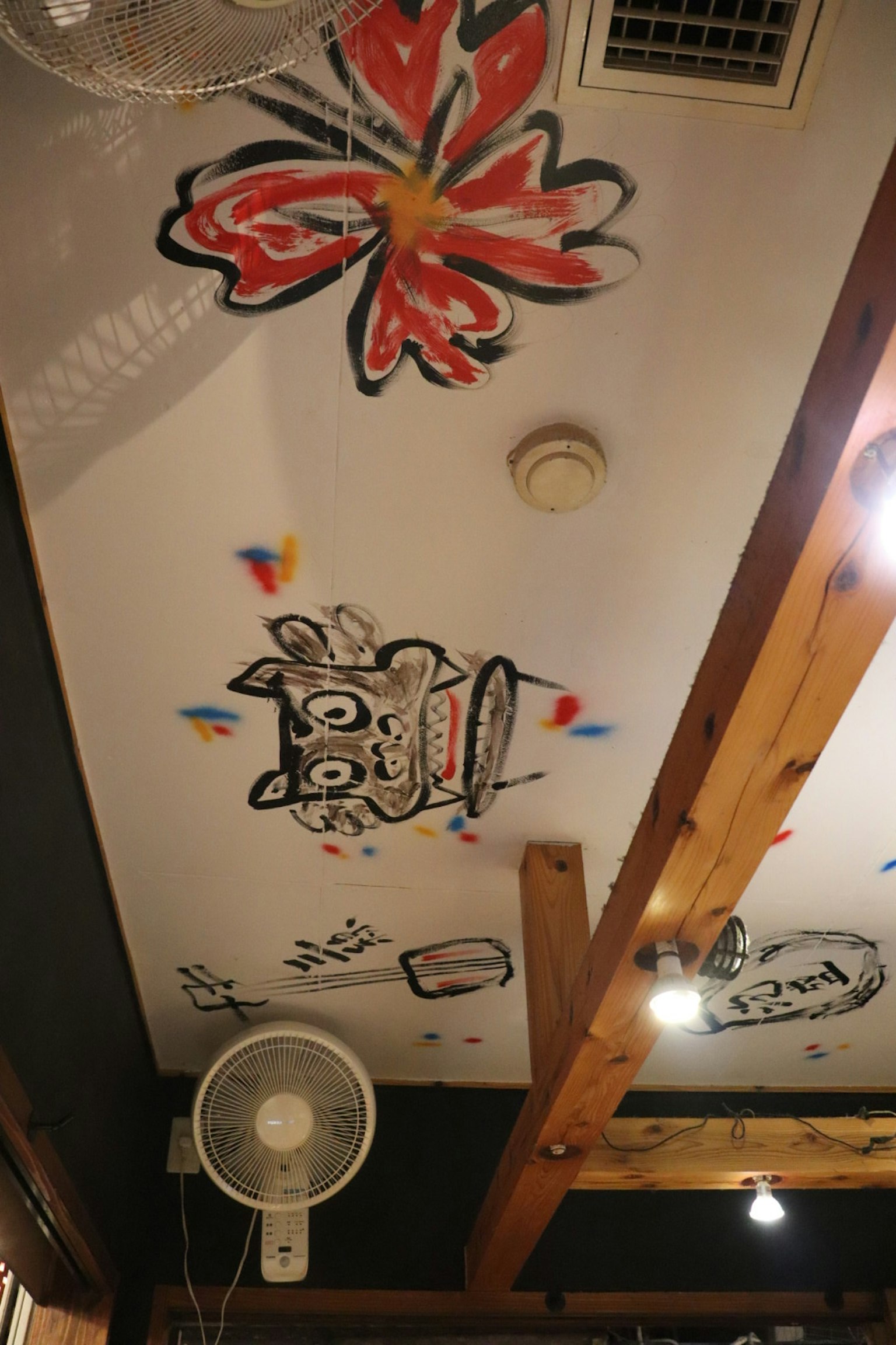 Grafiti berwarna bunga dan teks di langit-langit