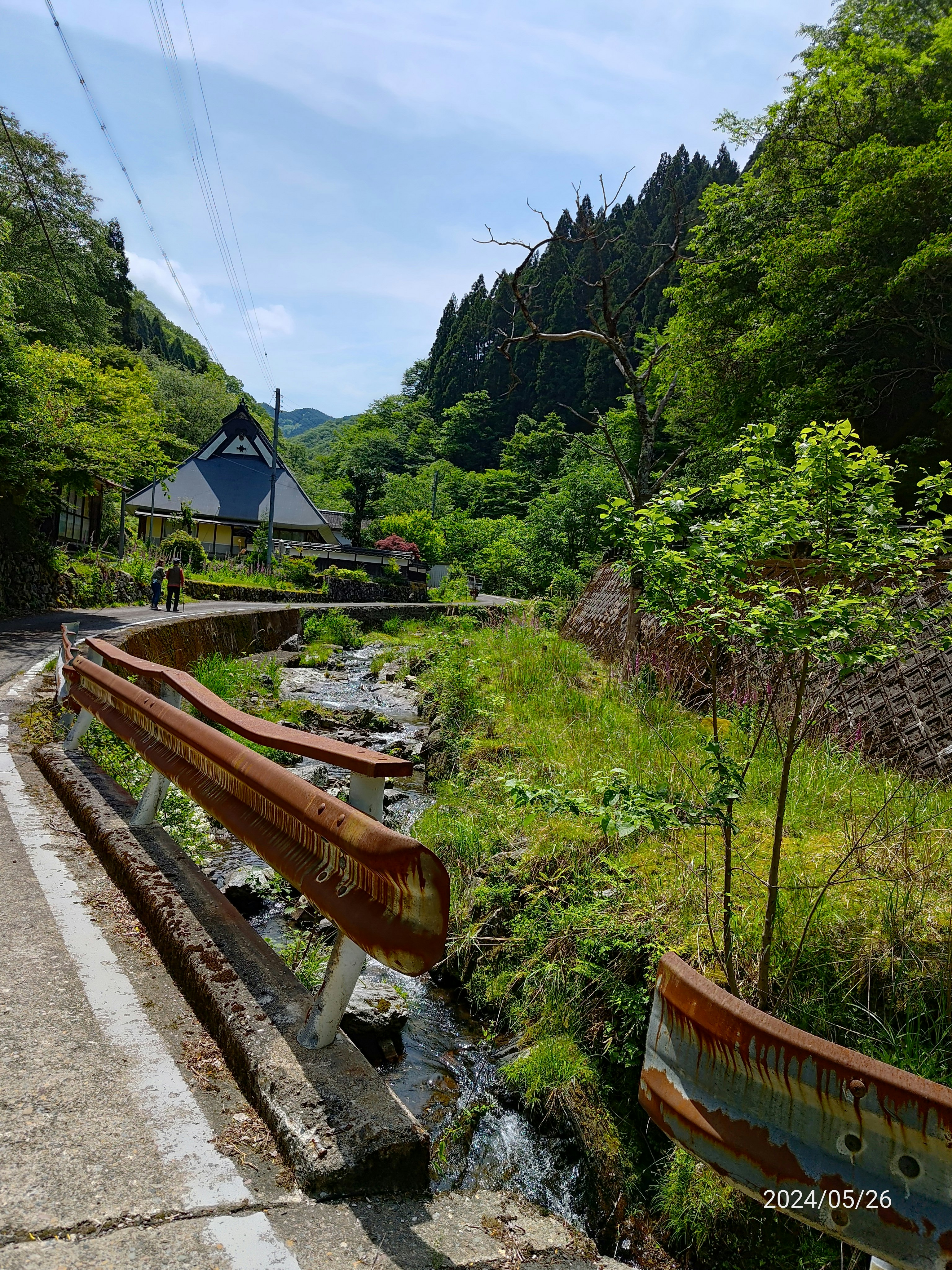 countryside houses and a path along a mountain stream
