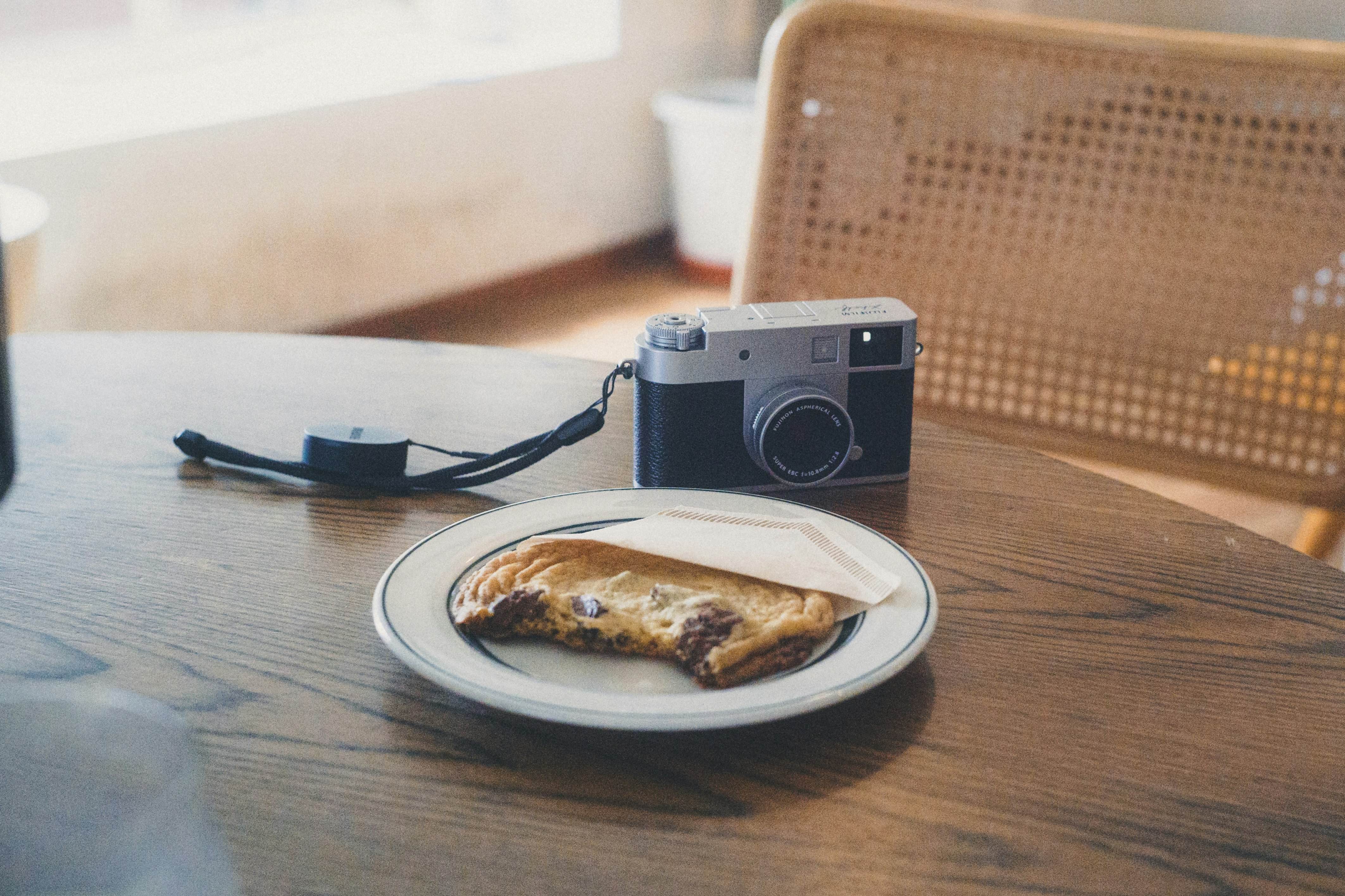 macchina fotografica e colazione su un tavolo di legno