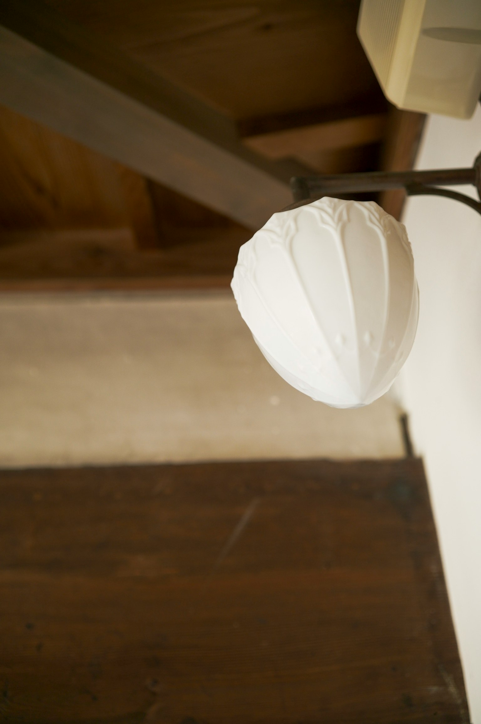 Lampada bianca appesa al soffitto in una stanza di legno