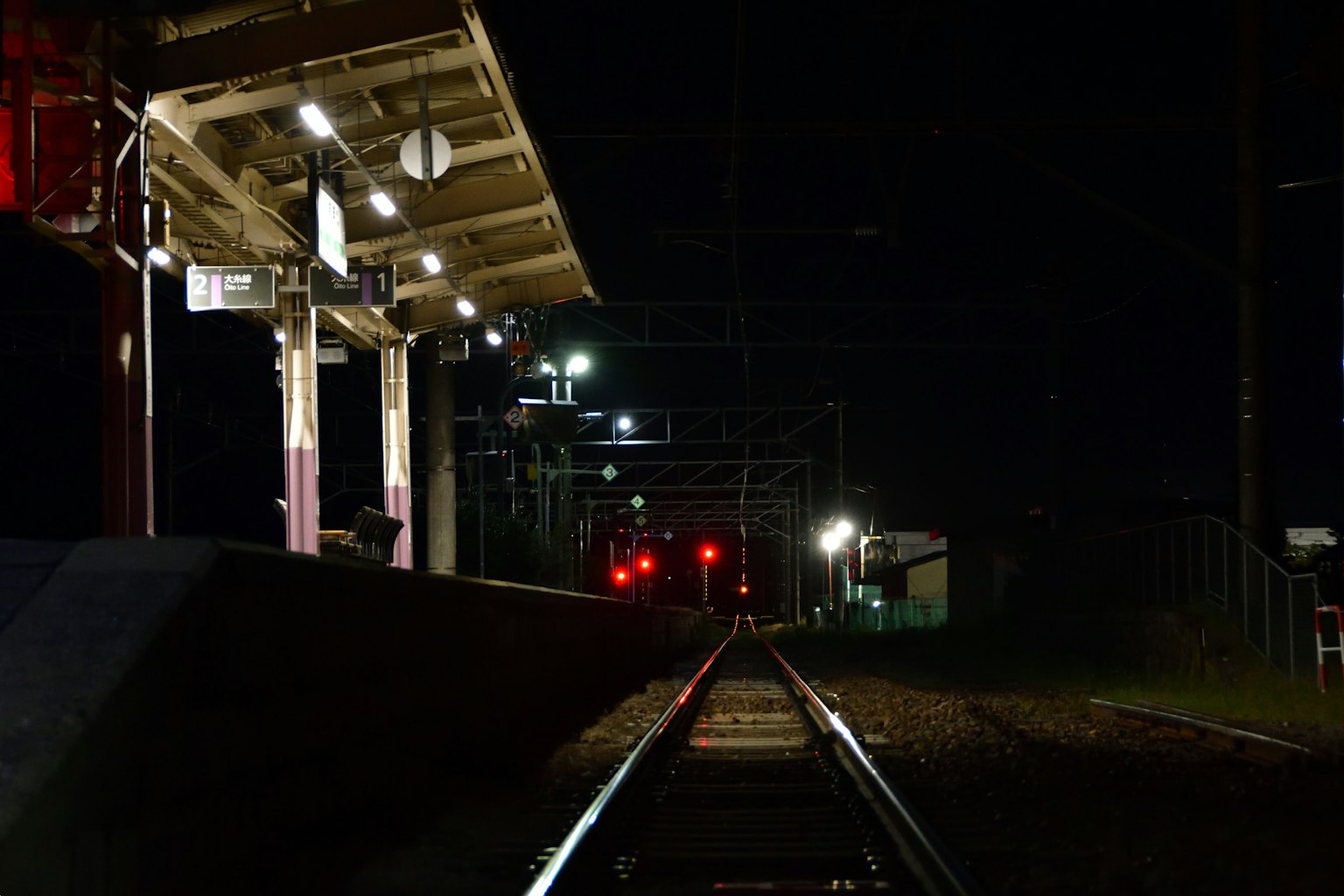 Vista notturna di una piattaforma ferroviaria e binari