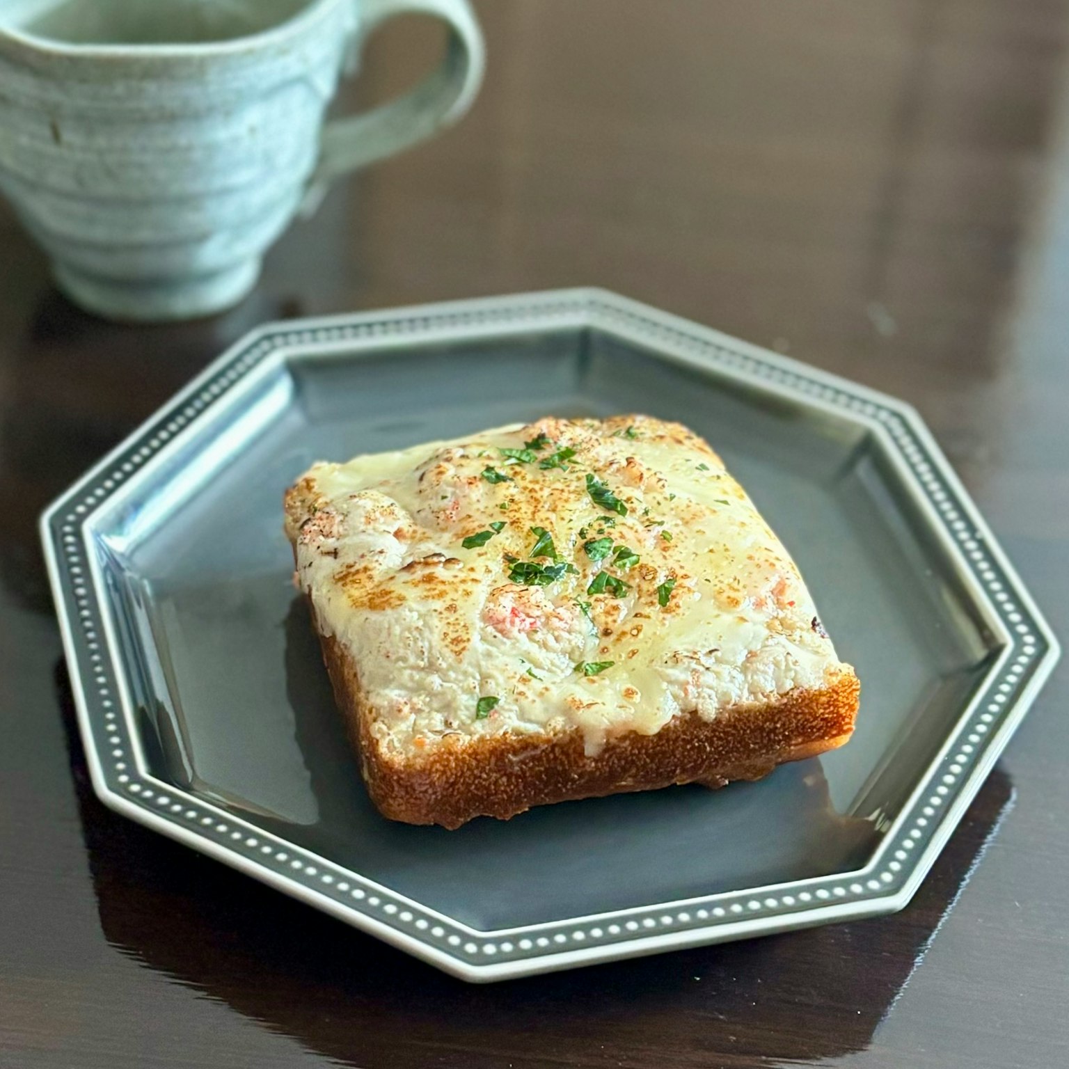 Slice of toasted bread topped with cheese and herbs