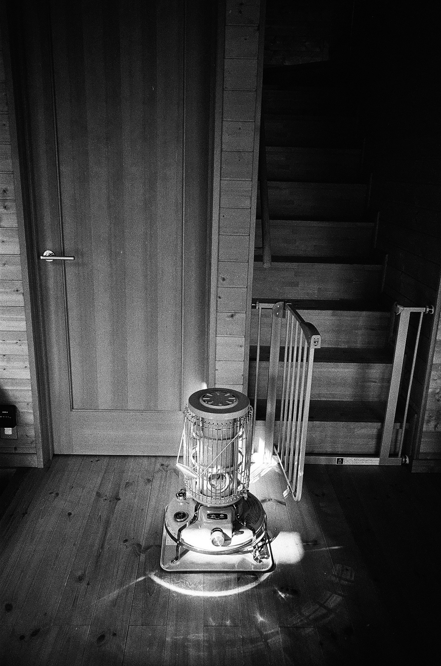 Schwarz-weiß Innenansicht mit einer vintage Lampe in der Nähe einer Treppe und einer Tür