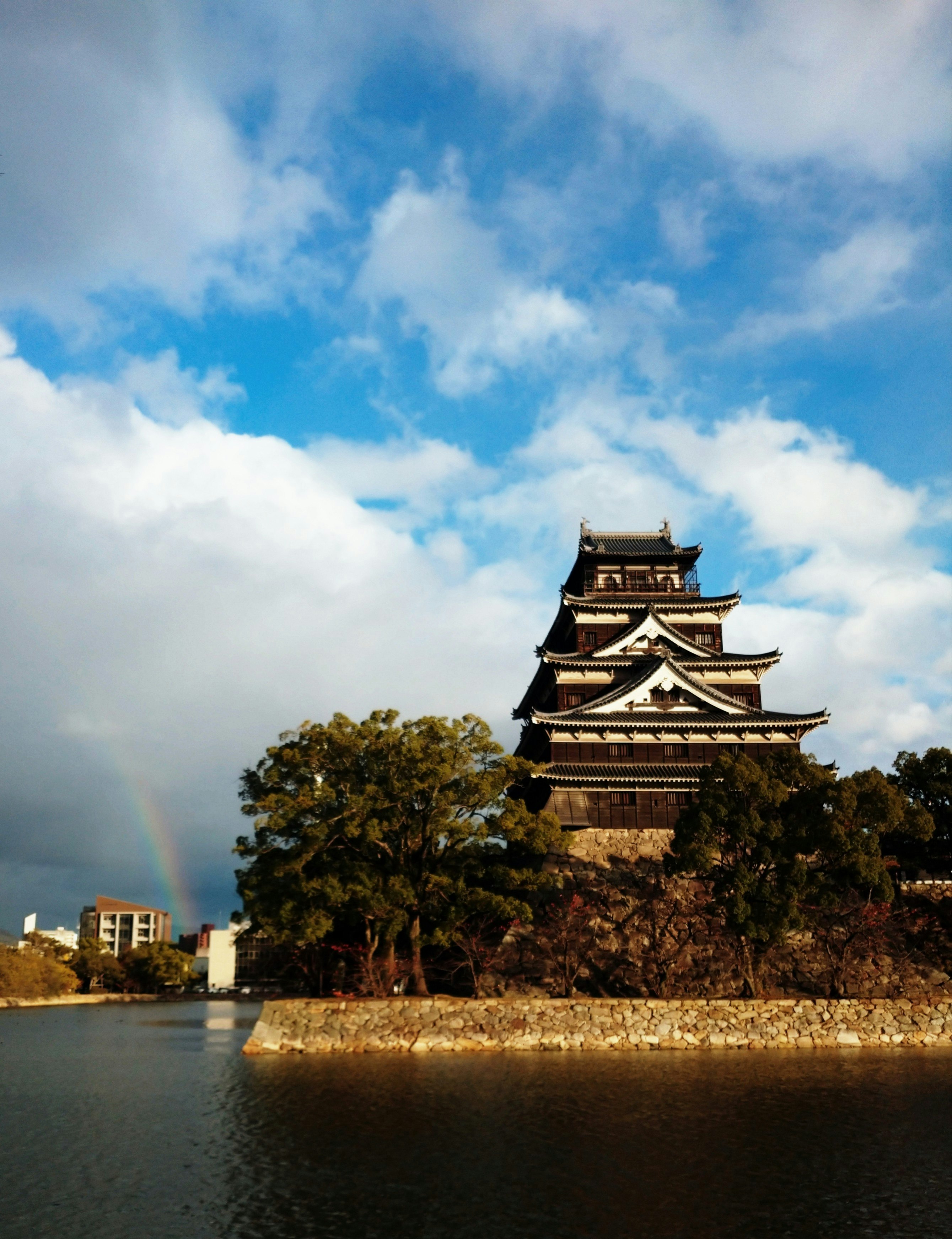 広島城と虹がかかる空の下の風景