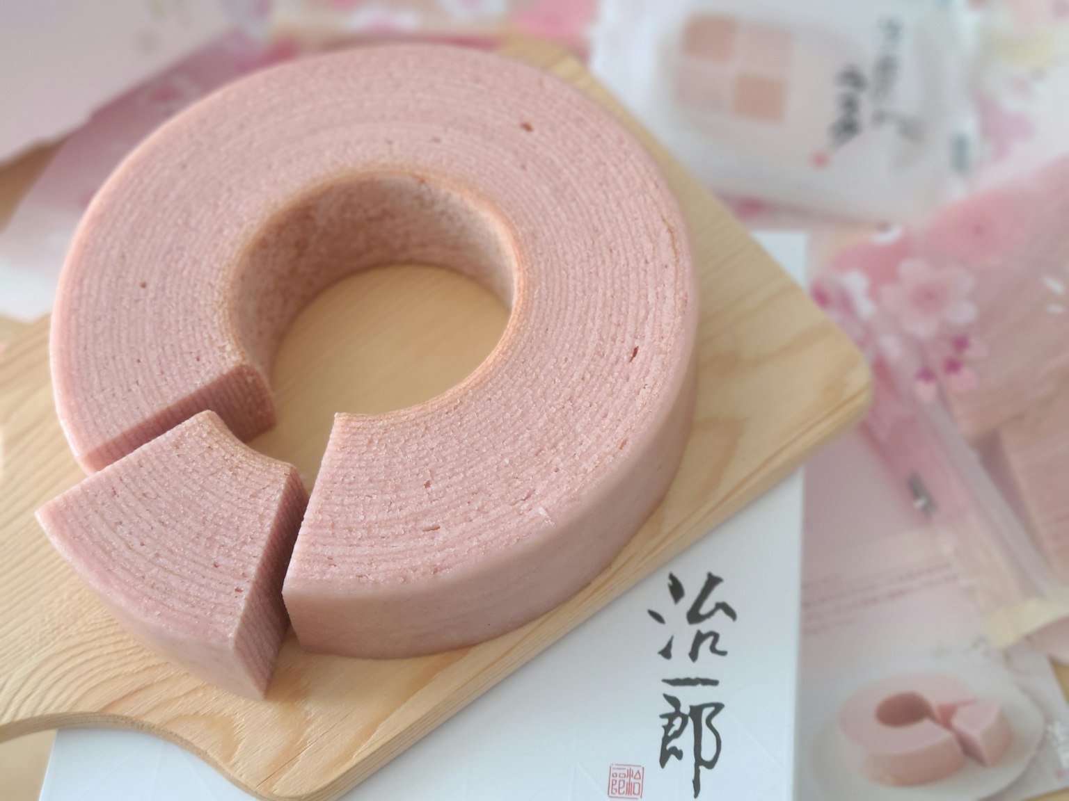 Un bellissimo Baumkuchen rosa posato su un piatto di legno