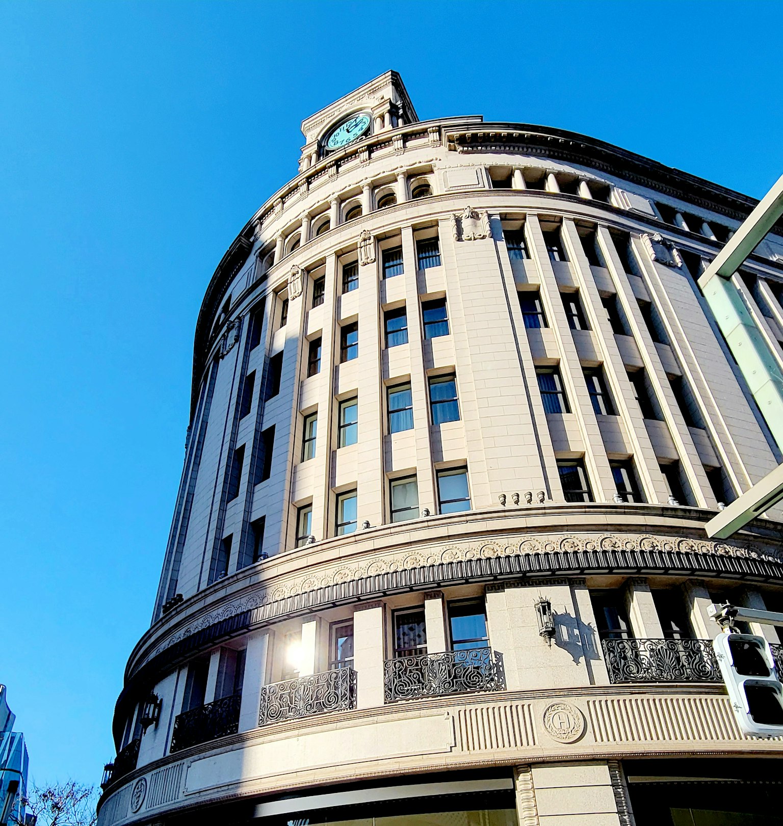 ทิวทัศน์เมืองมีอาคารทรงกลมและนาฬิกาอยู่ในพื้นหลังท้องฟ้าสีฟ้า